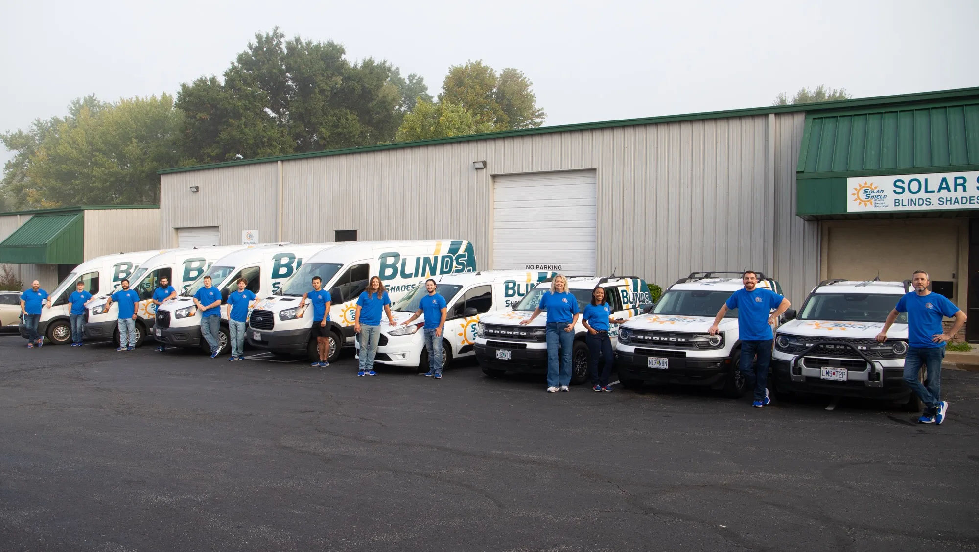 The whole Solar Shield Blinds team lined up with the fleet outside the warehouse