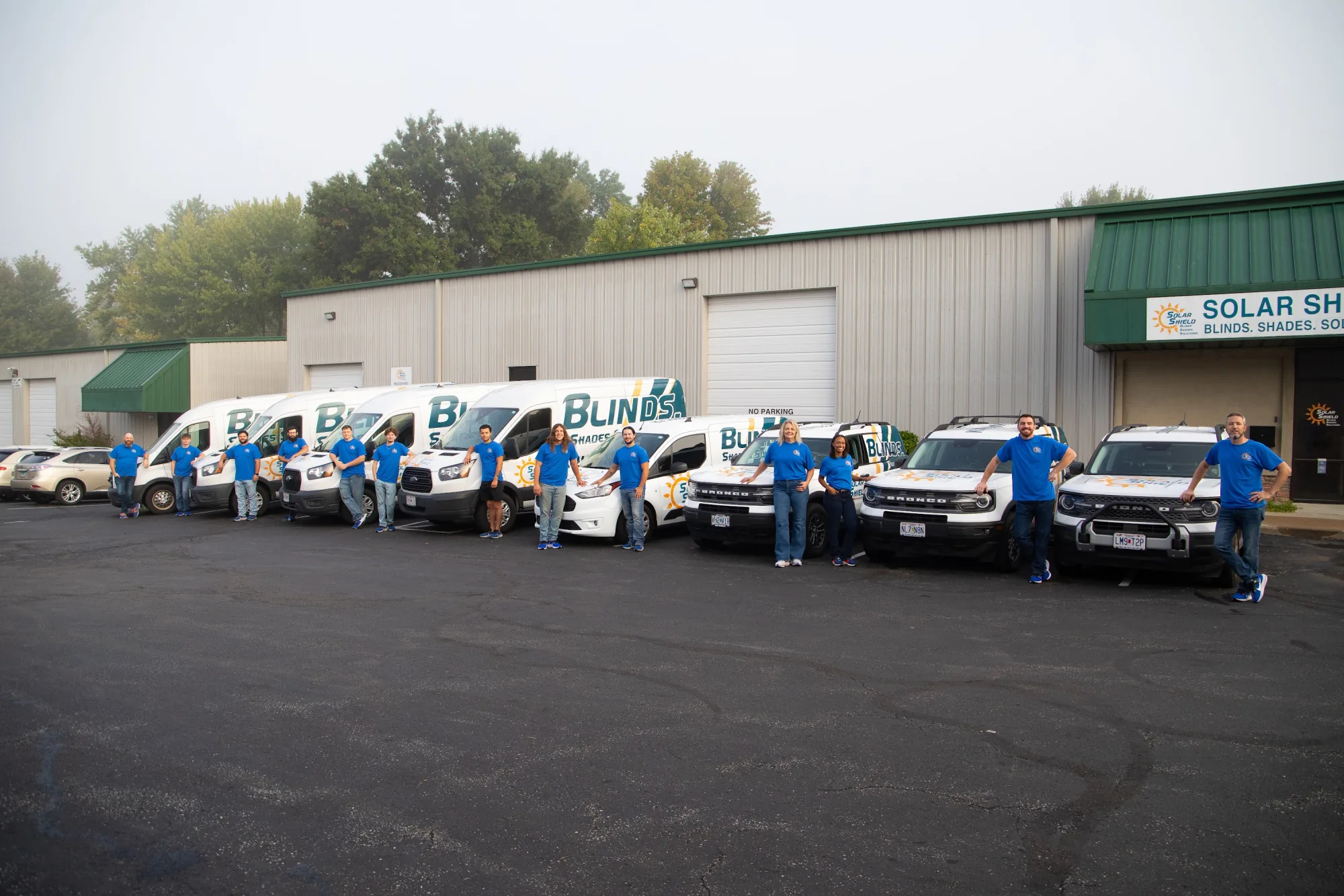 The Solar Shield Blinds team lined up with the fleet outside the warehouse