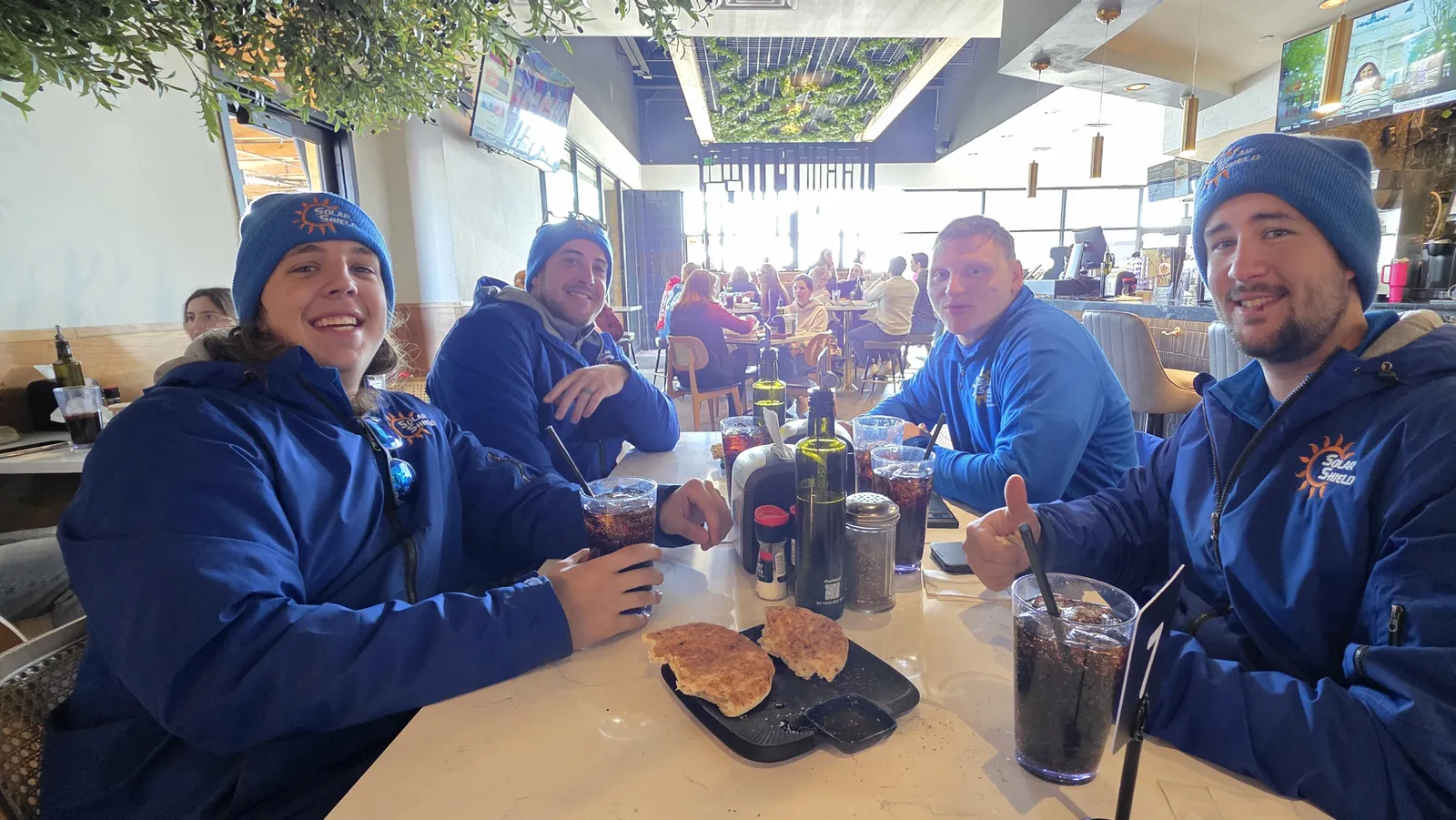 The install crew sharing a meal in Solar Shield Blinds hoodies