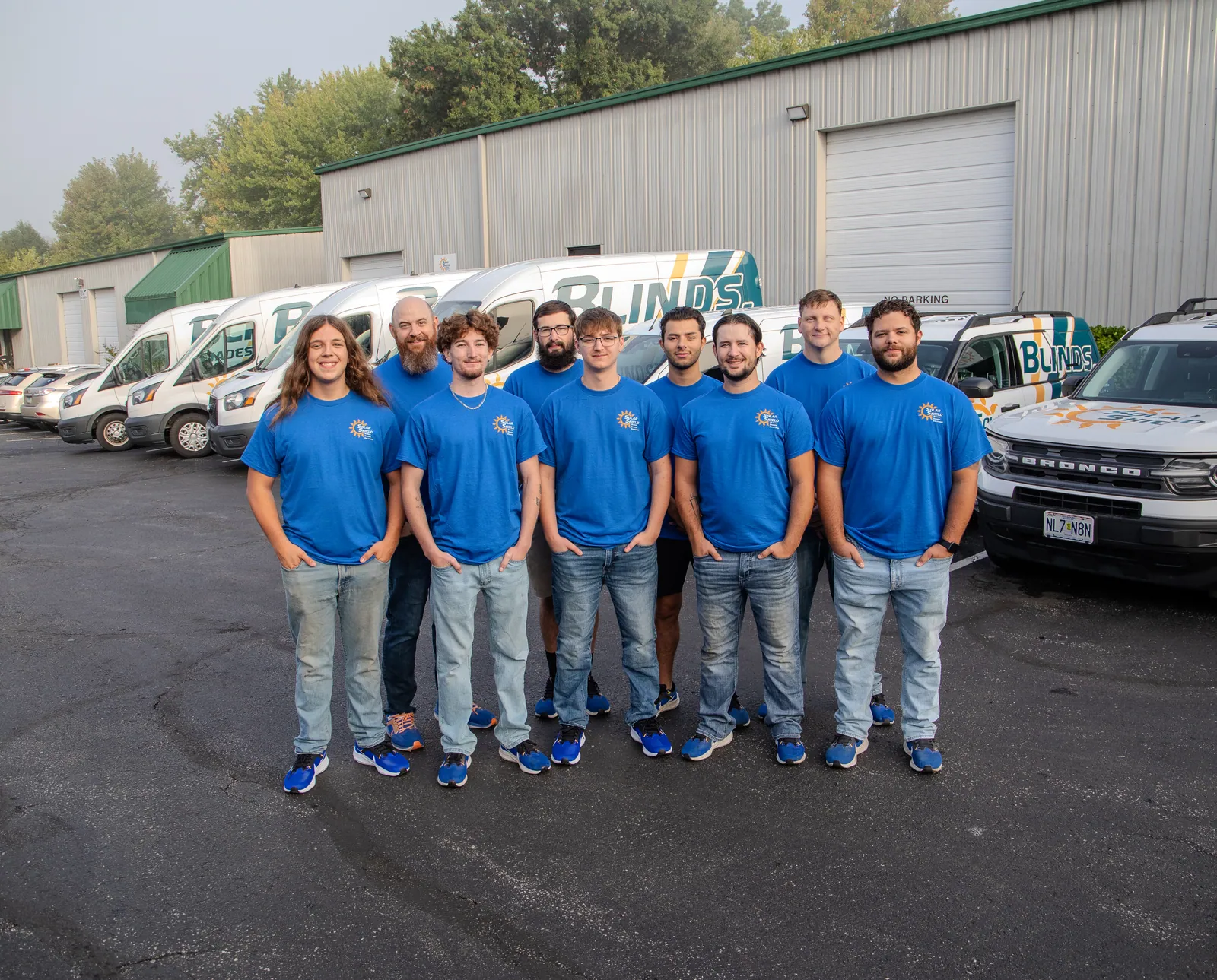 The Solar Shield Blinds install crew outside the warehouse with the fleet behind them
