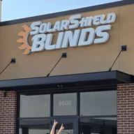 The Solar Shield Blinds sign above the showroom door