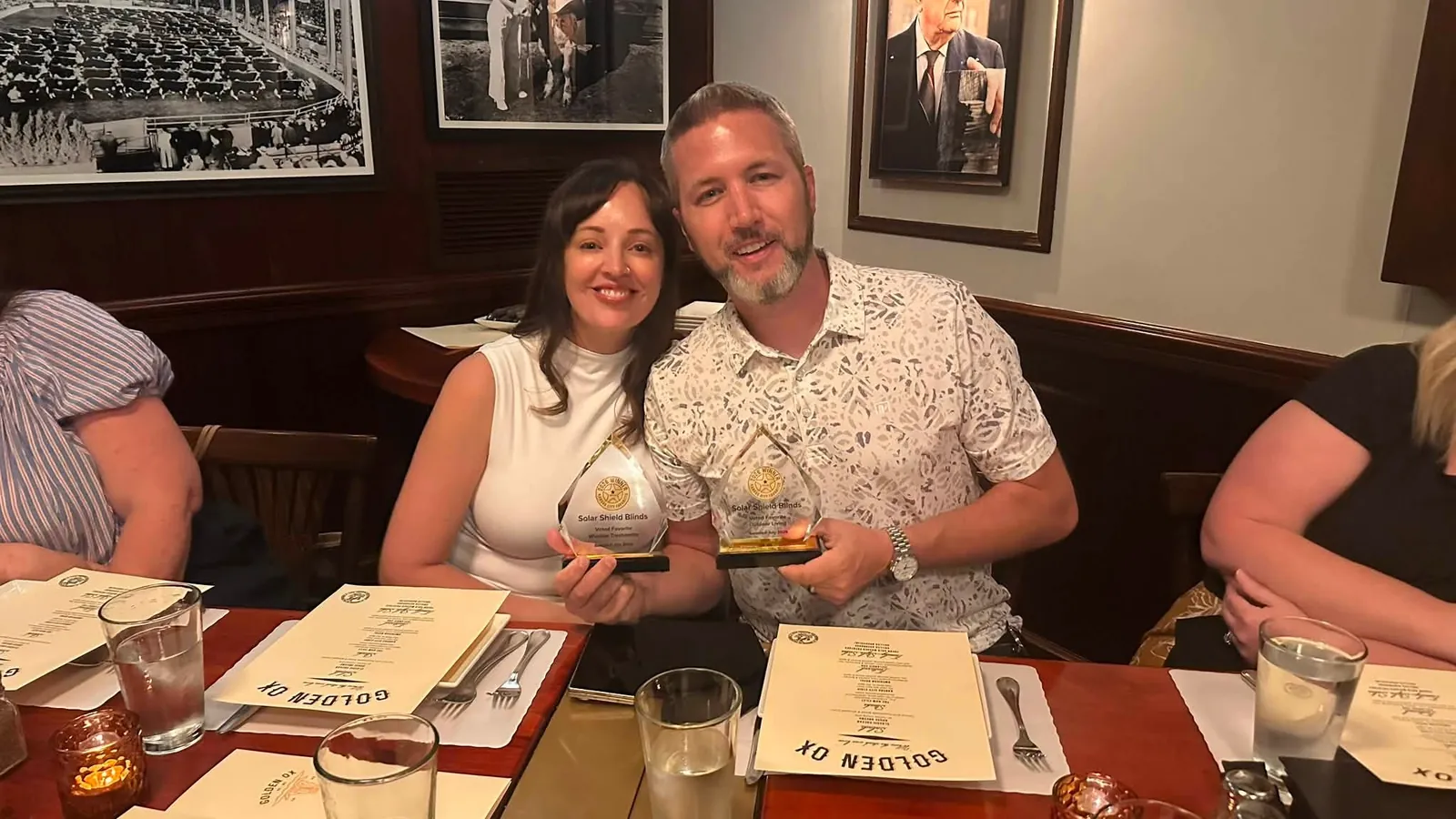 Two team members holding an award at a dinner