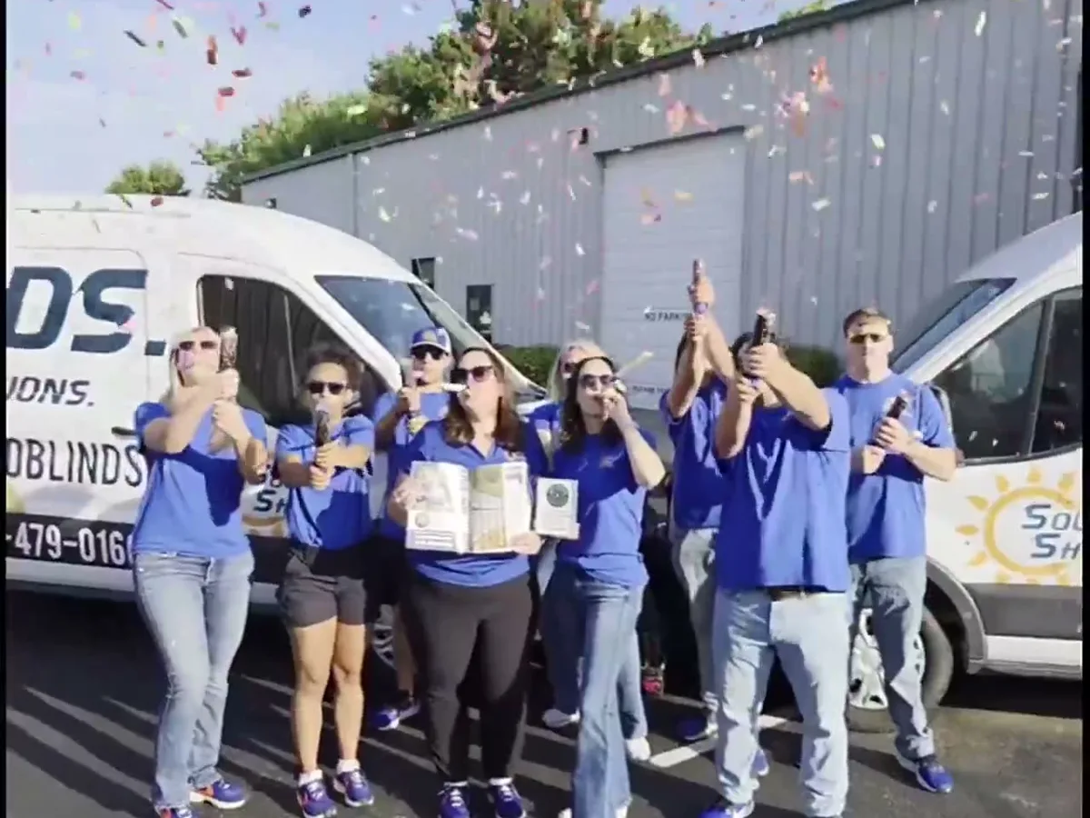 The Solar Shield Blinds team celebrating the Kansas City Favorites award with the trophy and confetti
