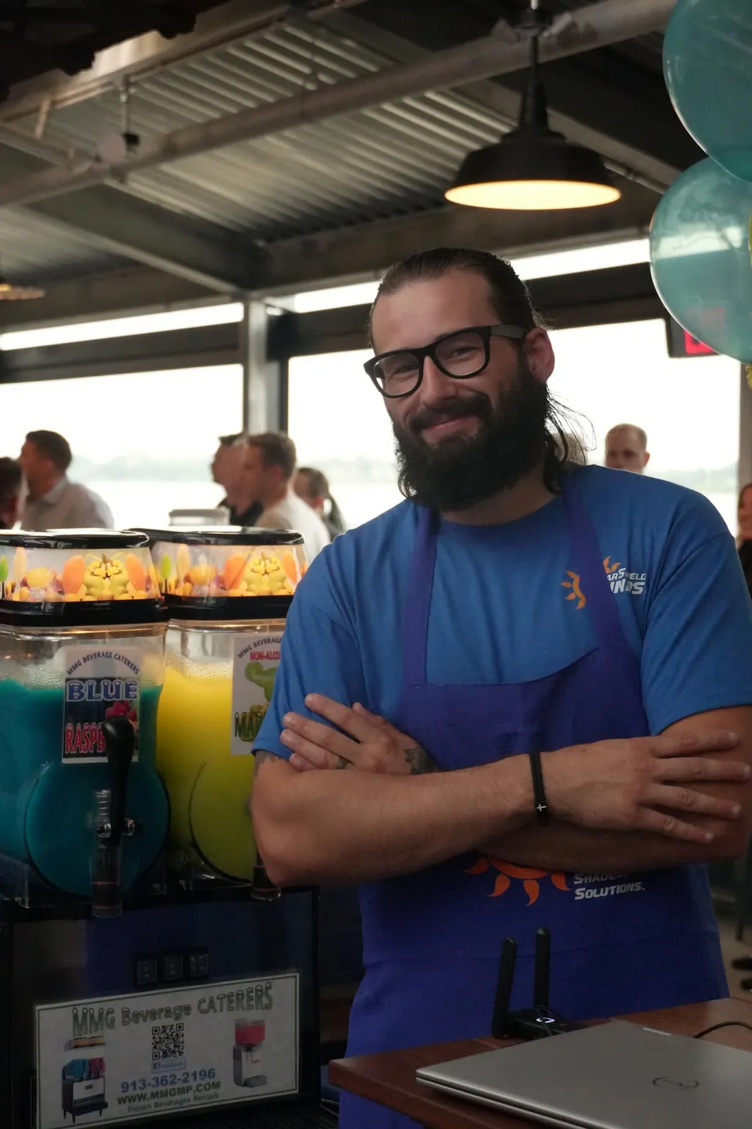 A team member in a Solar Shield Blinds apron at an event