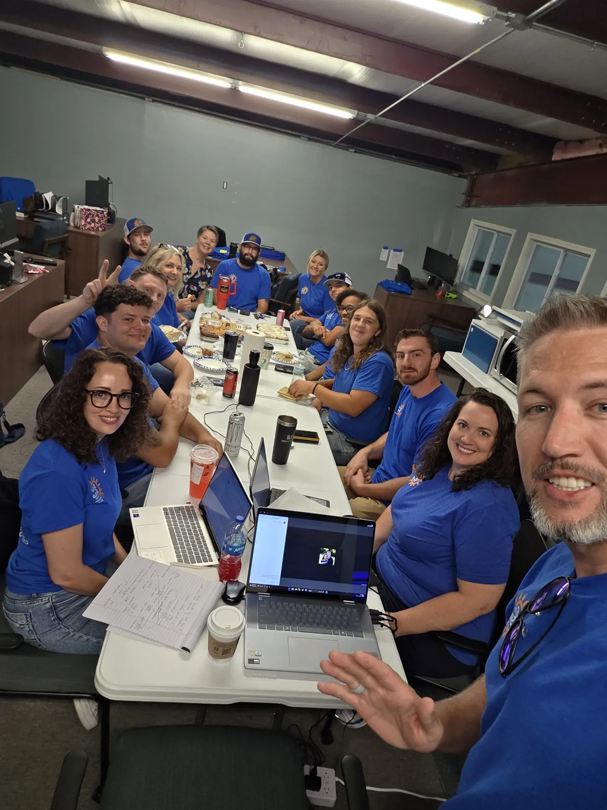 A selfie at a company meeting in the office, laptops out