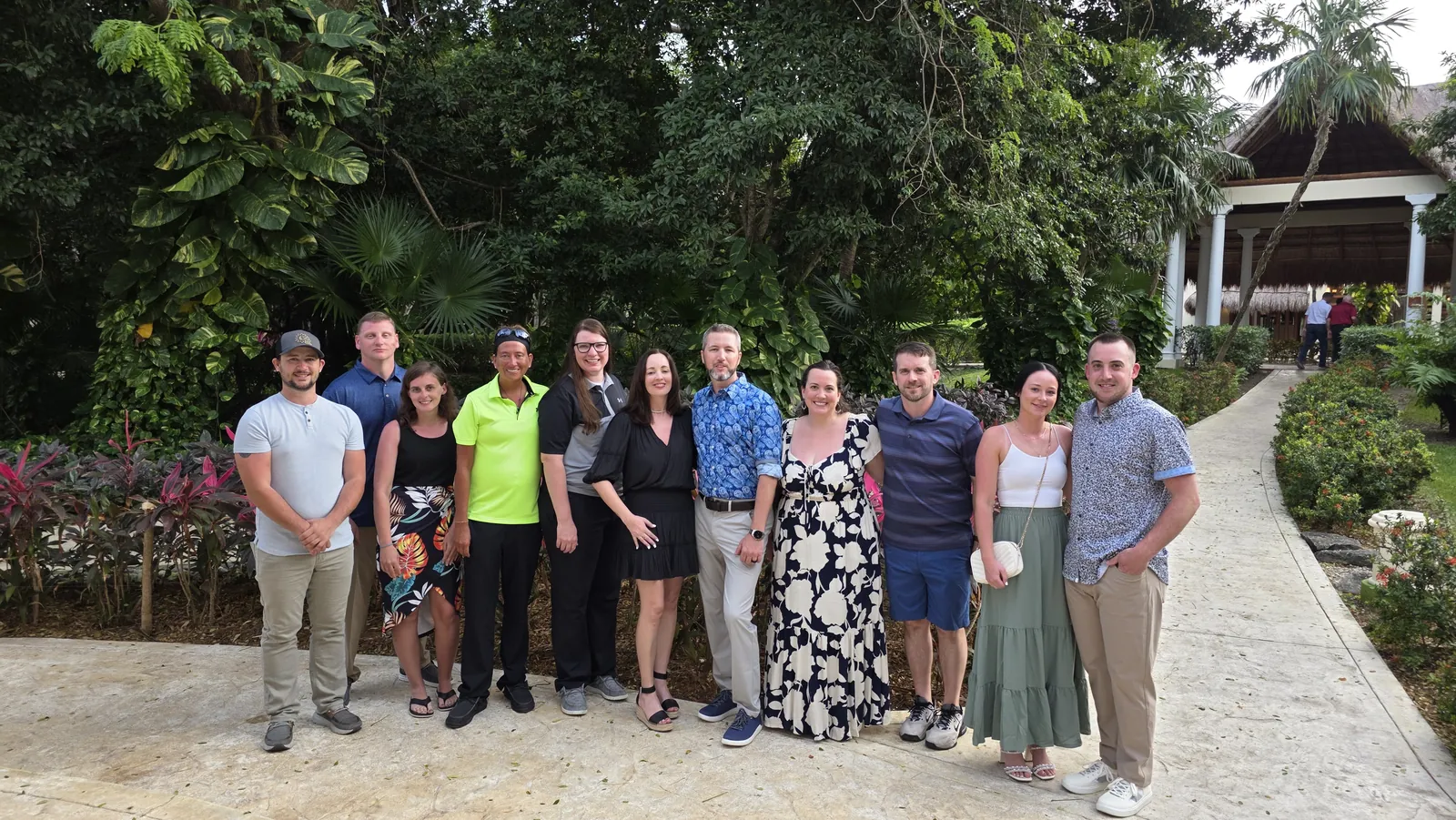The team together in a tropical garden on a company trip