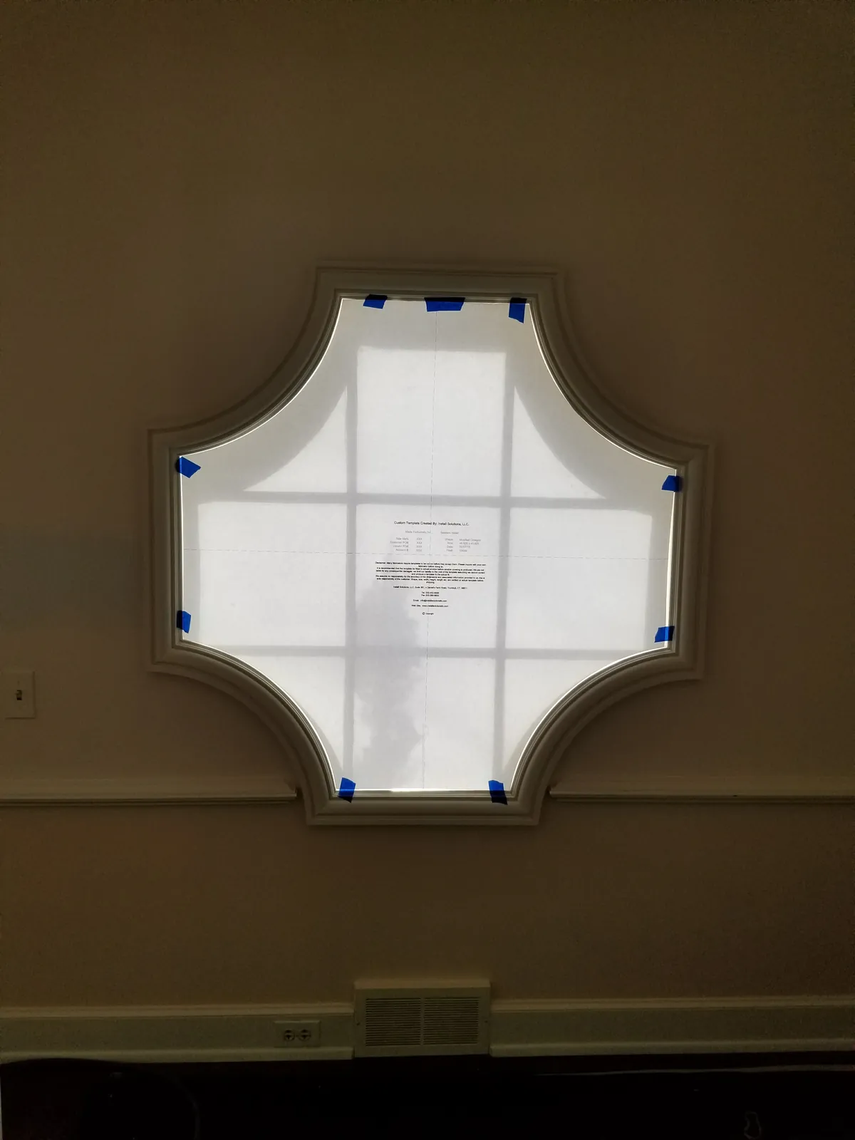 A paper template taped inside the cross pattern window, traced to every angle