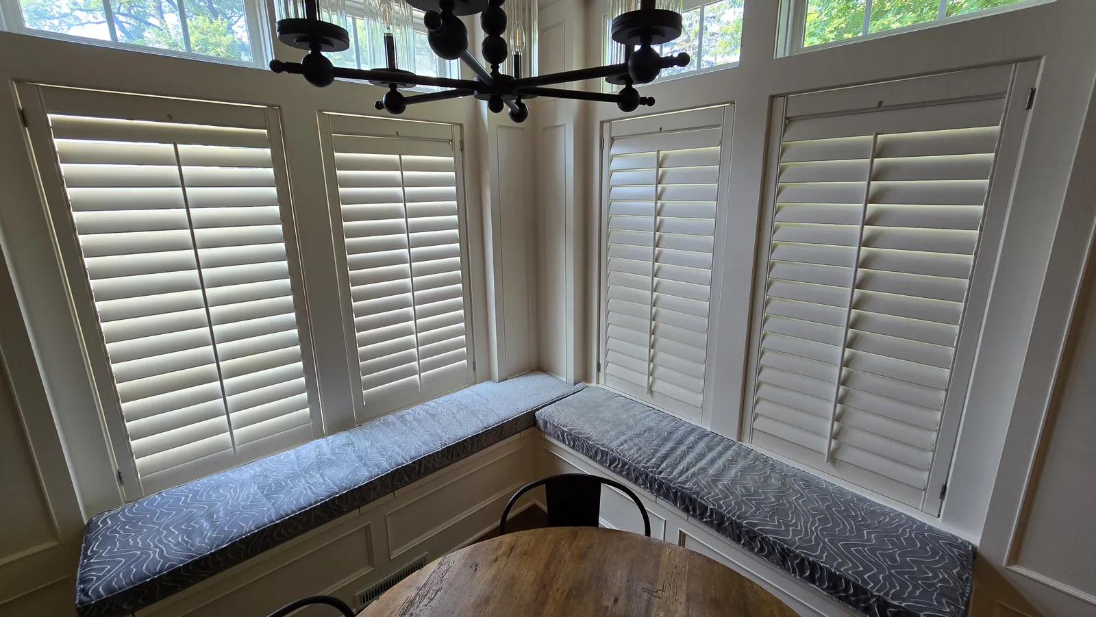 Banquette cushions under plantation shutters, installed by Solar Shield Blinds