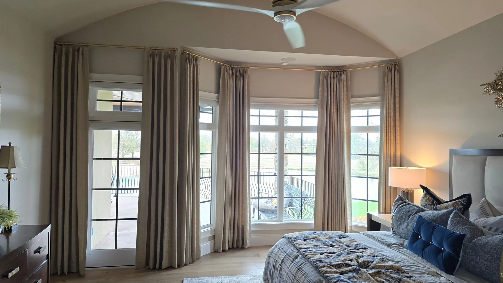 Drapery panels around a bedroom bay window, installed by Solar Shield Blinds
