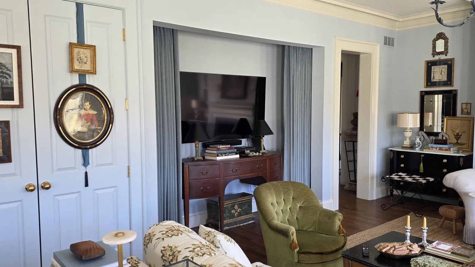 Blue velvet drapery panels framing a TV nook in a living room, installed by Solar Shield Blinds