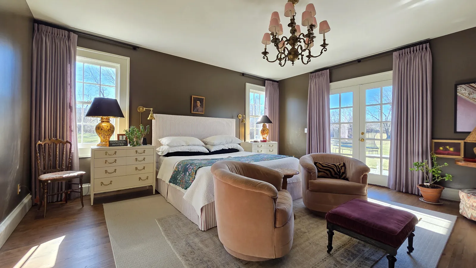 Mauve drapery panels on the windows and French doors of a primary bedroom, installed by Solar Shield Blinds