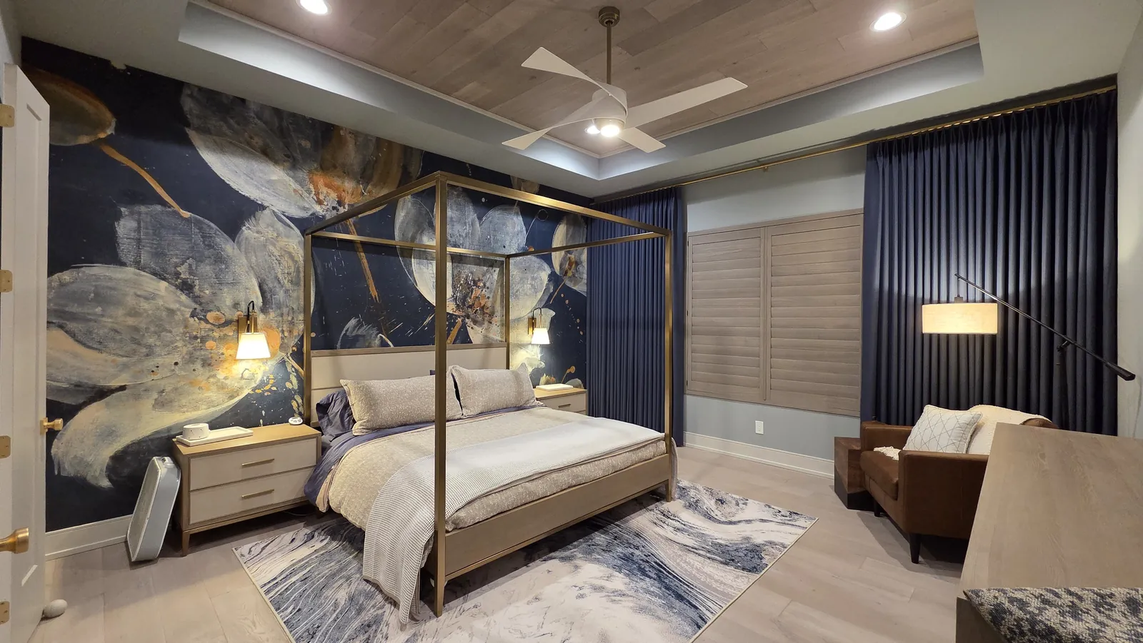 Navy drapery panels in a bedroom with a canopy bed and mural wallpaper, installed by Solar Shield Blinds