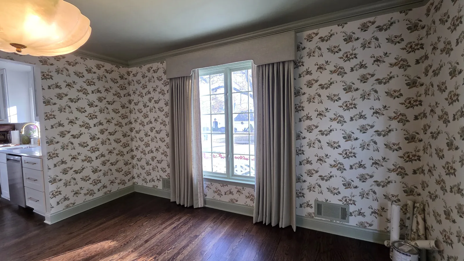 Drapery panels against floral wallpaper in a breakfast room, installed by Solar Shield Blinds