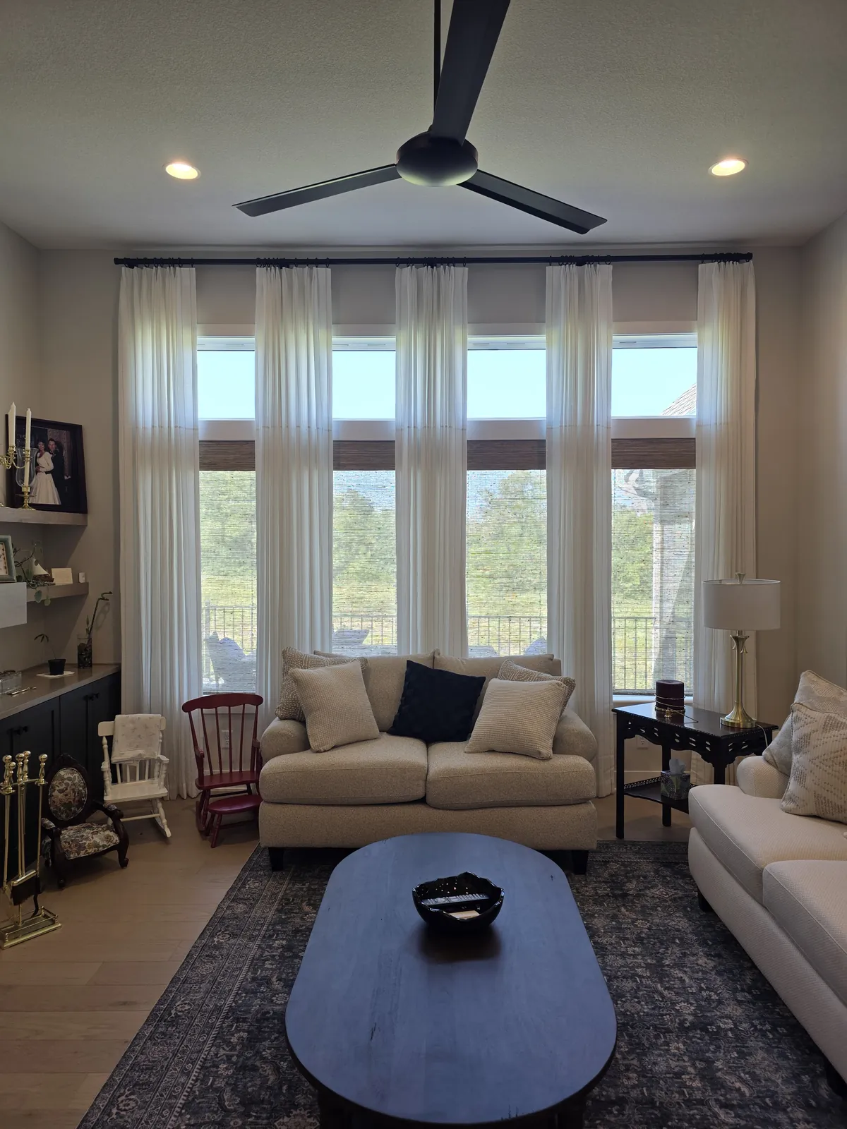 Sheer drapery panels on tall windows in a sitting room, installed by Solar Shield Blinds