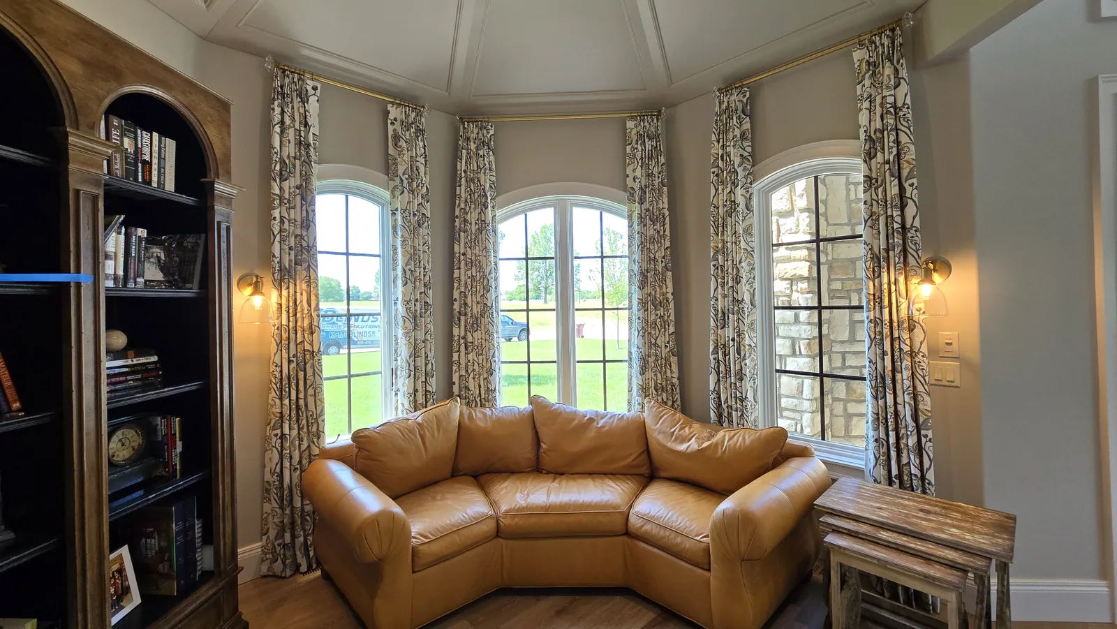 Patterned drapery panels on arched windows, installed by Solar Shield Blinds
