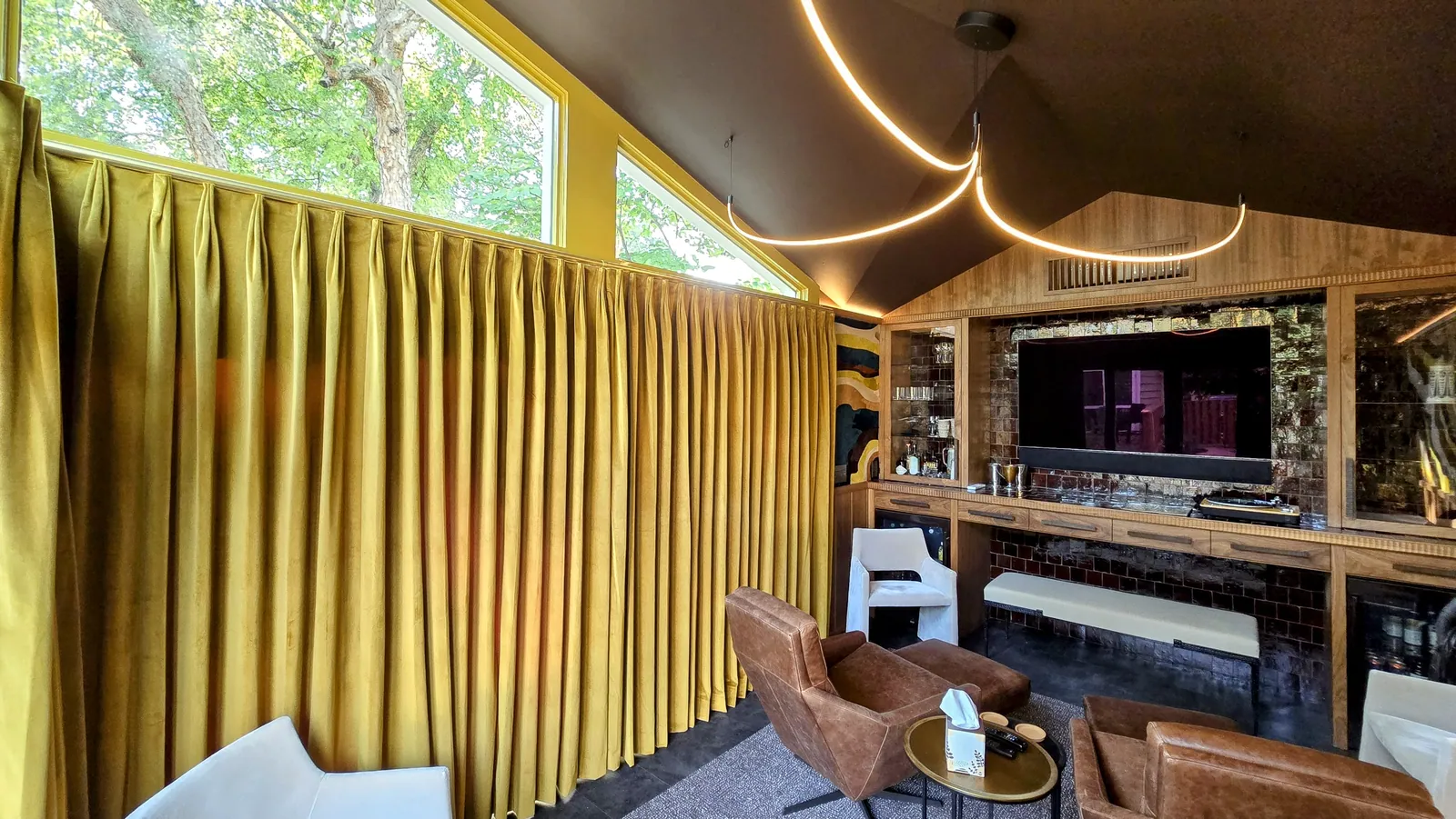 Gold drapery on a ceiling mounted track in a media room, installed by Solar Shield Blinds