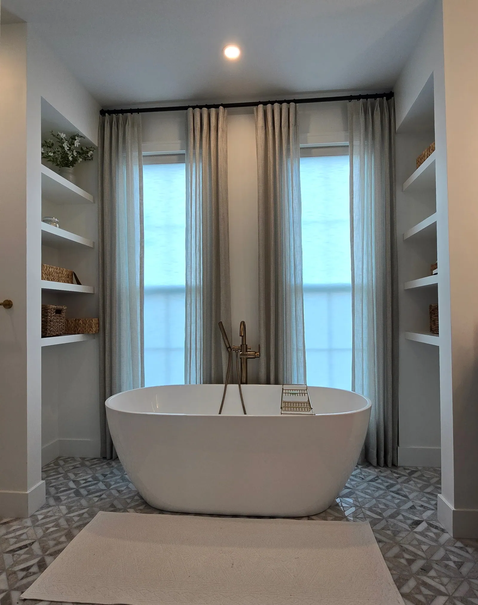 Sheer drapery panels behind a freestanding tub, installed by Solar Shield Blinds