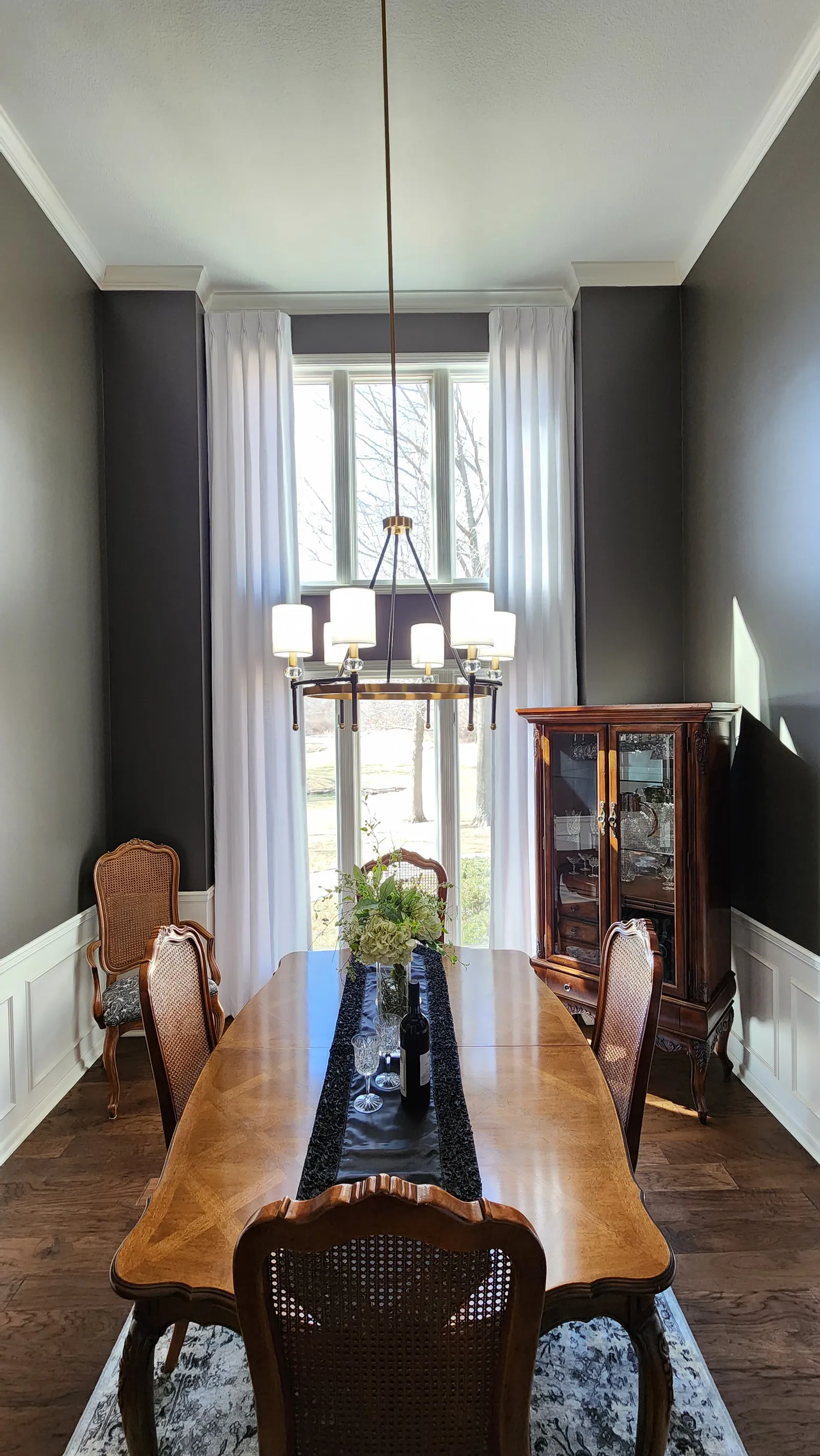 Sheer panels on a tall dining room window, installed by Solar Shield Blinds