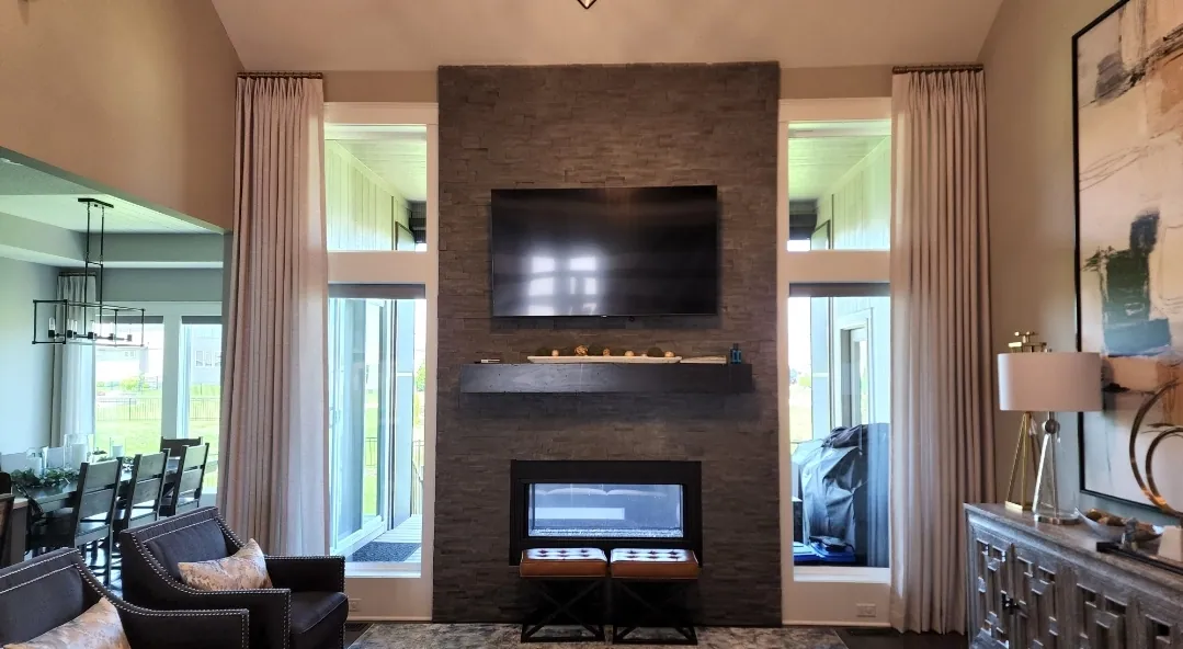 Drapery panels either side of a fireplace wall, installed by Solar Shield Blinds