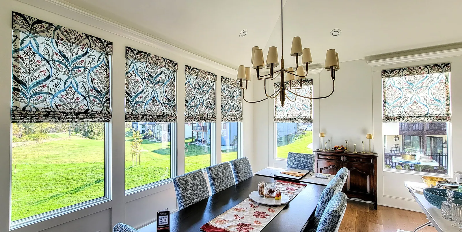 Patterned Roman shades in a dining room, installed by Solar Shield Blinds