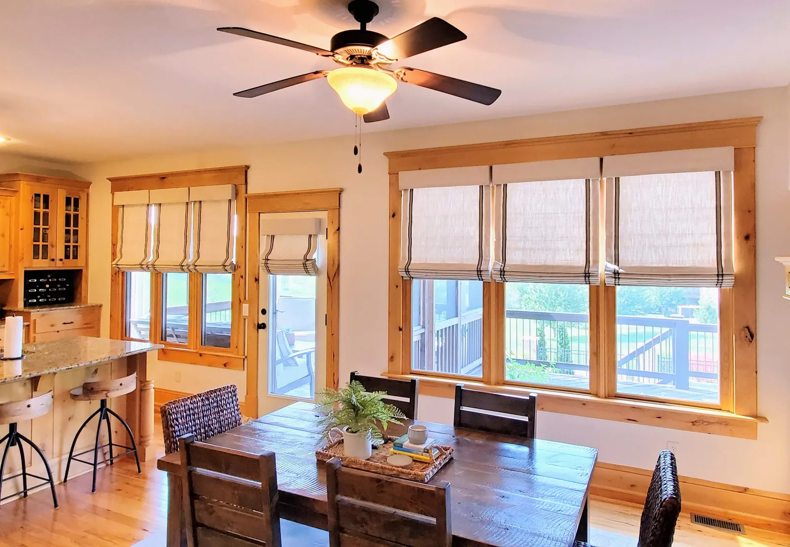Roman shades in a dining room, measured and hung by Solar Shield Blinds
