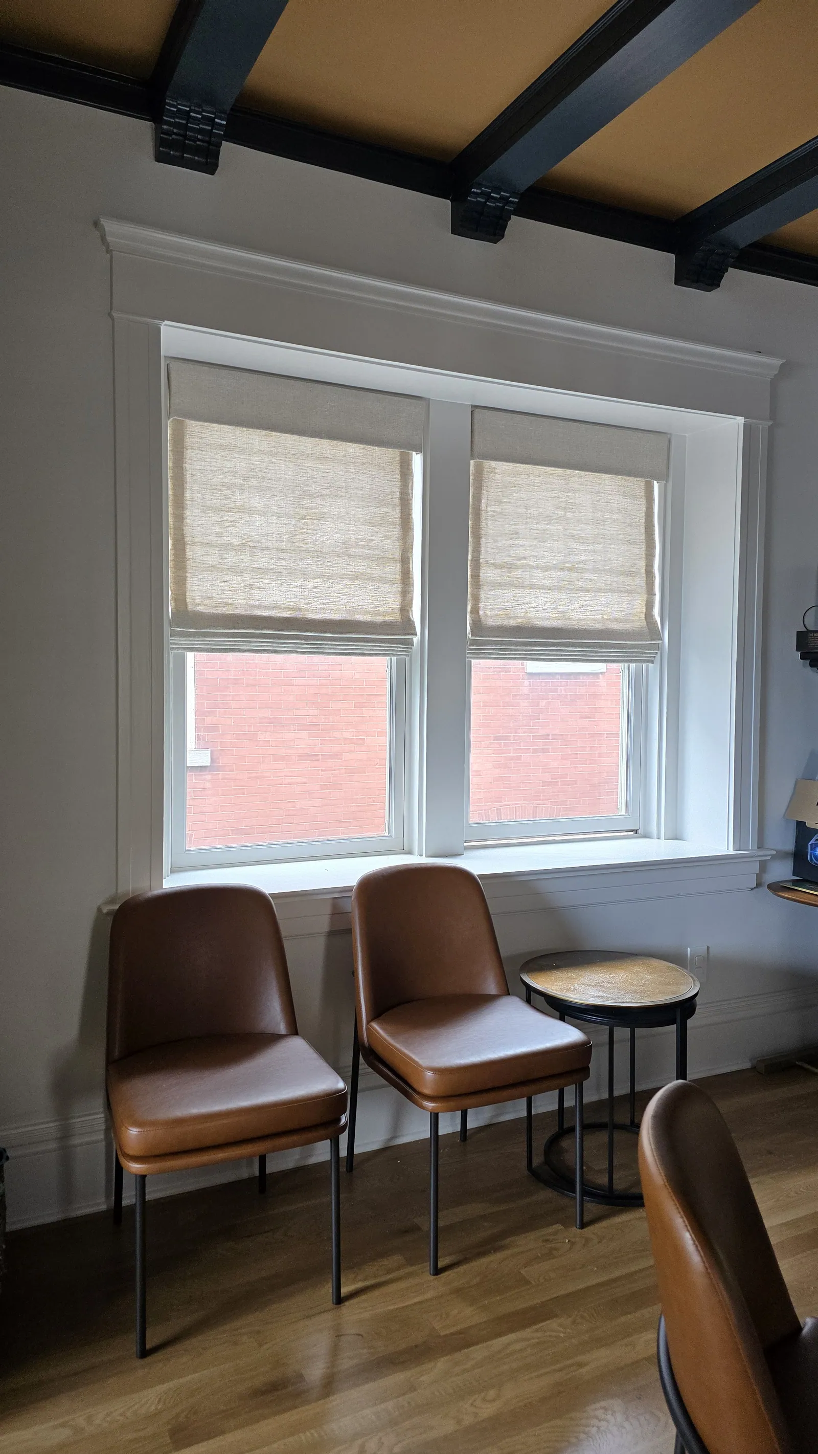 Roman shades in a sitting area, installed by Solar Shield Blinds