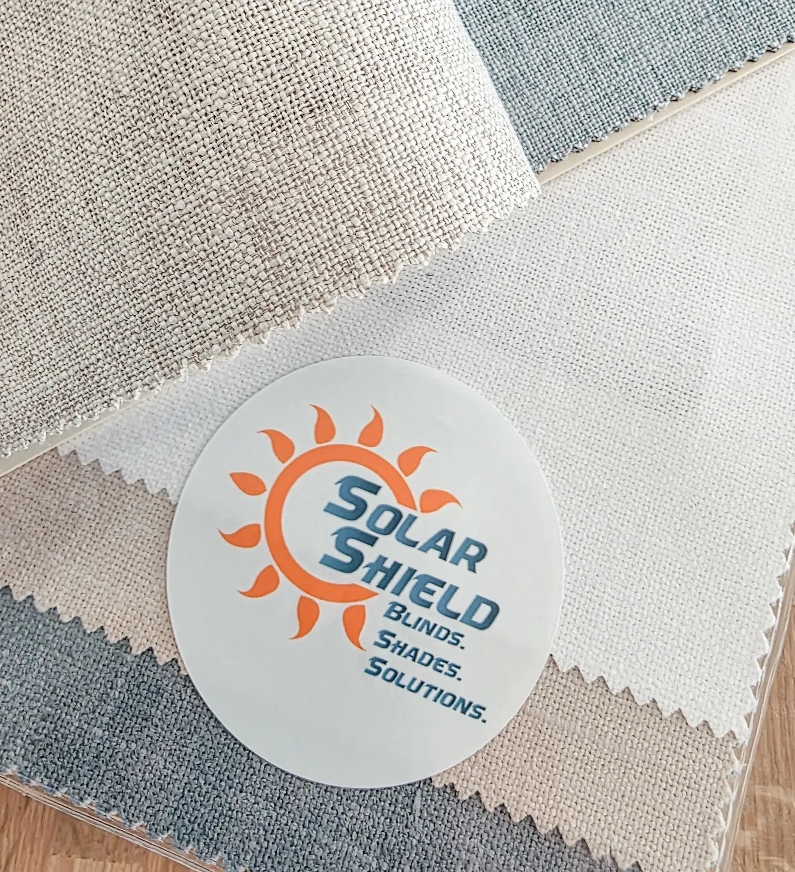 Solar Shield Blinds fabric samples fanned out with a branded swatch button