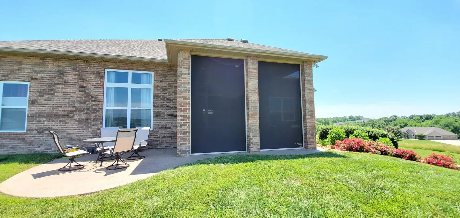 Motorized exterior shades closed around a covered patio