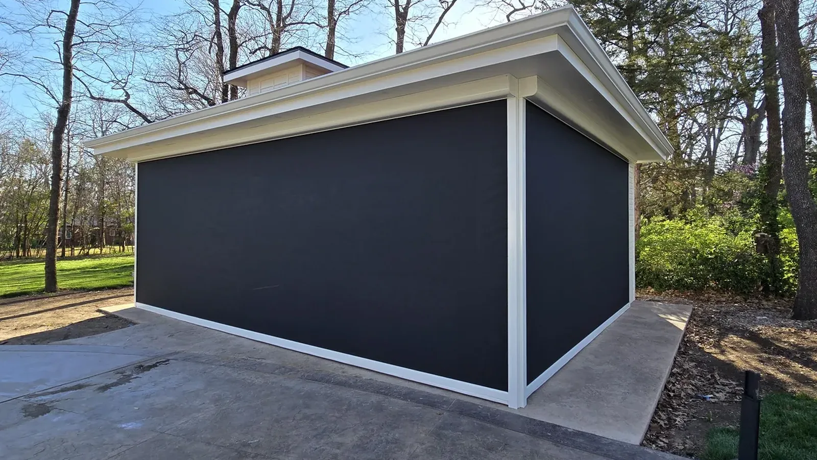 The same patio with motorized exterior shades lowered, enclosed against sun and wind