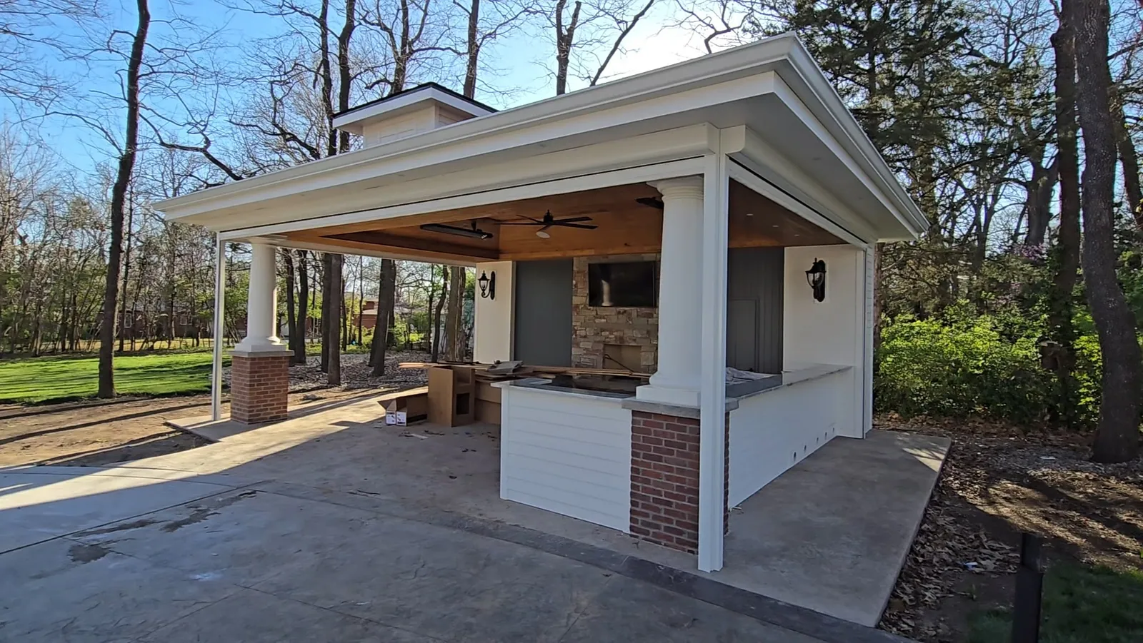 A covered patio before exterior shades, open on every side to sun and wind