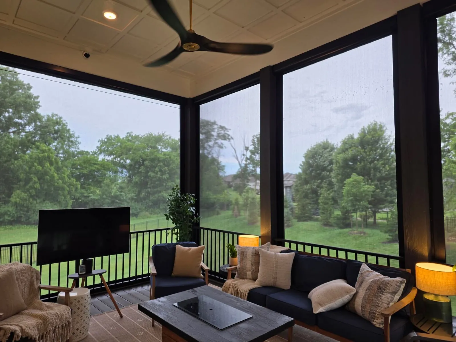 A covered patio behind lowered exterior patio shades, clear and dry after a thunderstorm
