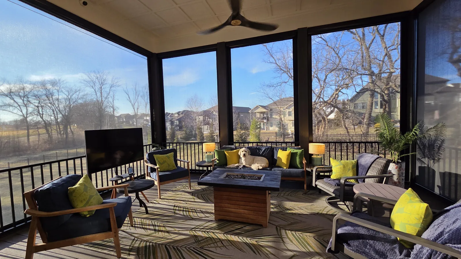 A covered deck closed in with exterior patio shades on a bare-tree winter day