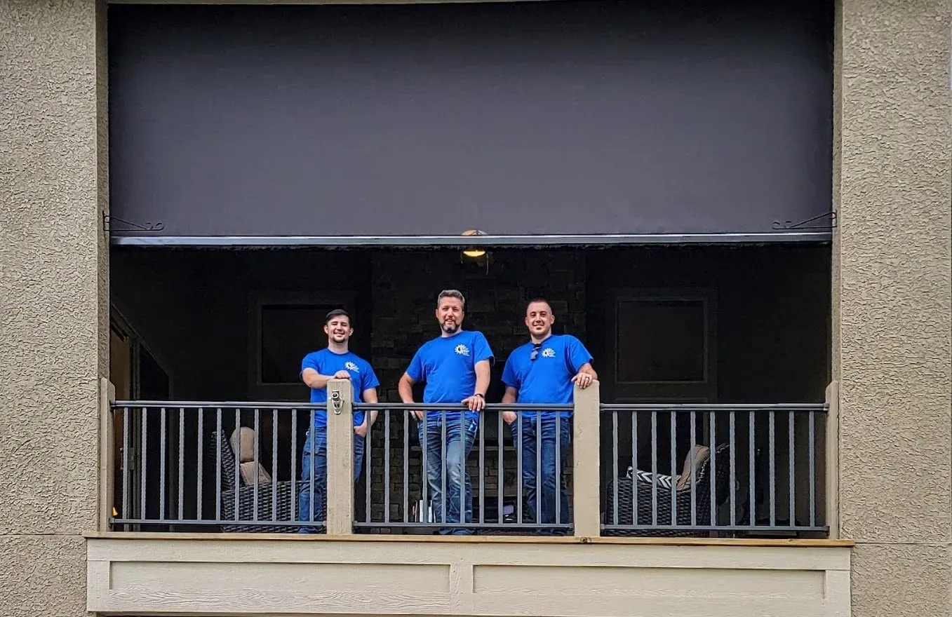 The Solar Shield Blinds crew fitting exterior patio shades on an upper level patio