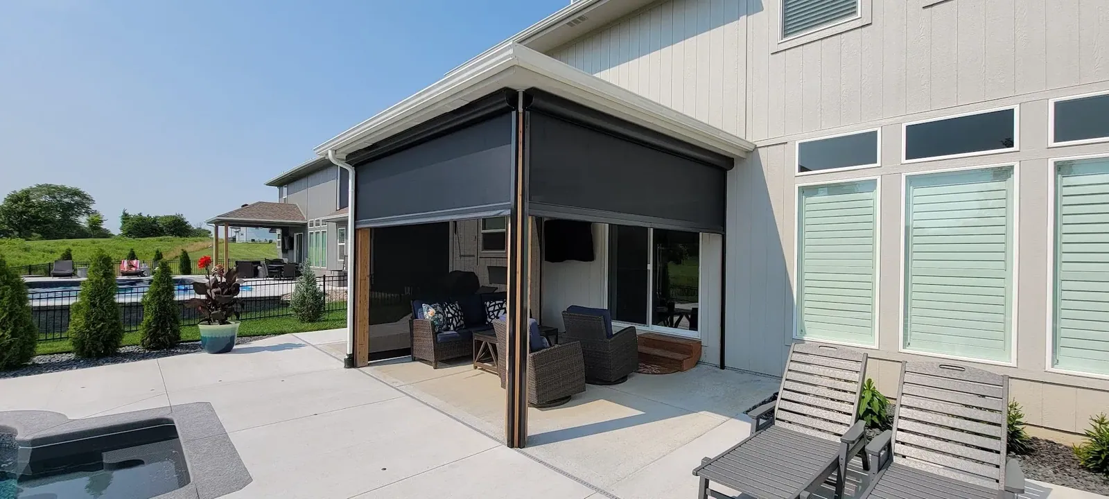 Custom exterior patio shades half open motorized lower, installed by Solar Shield Blinds