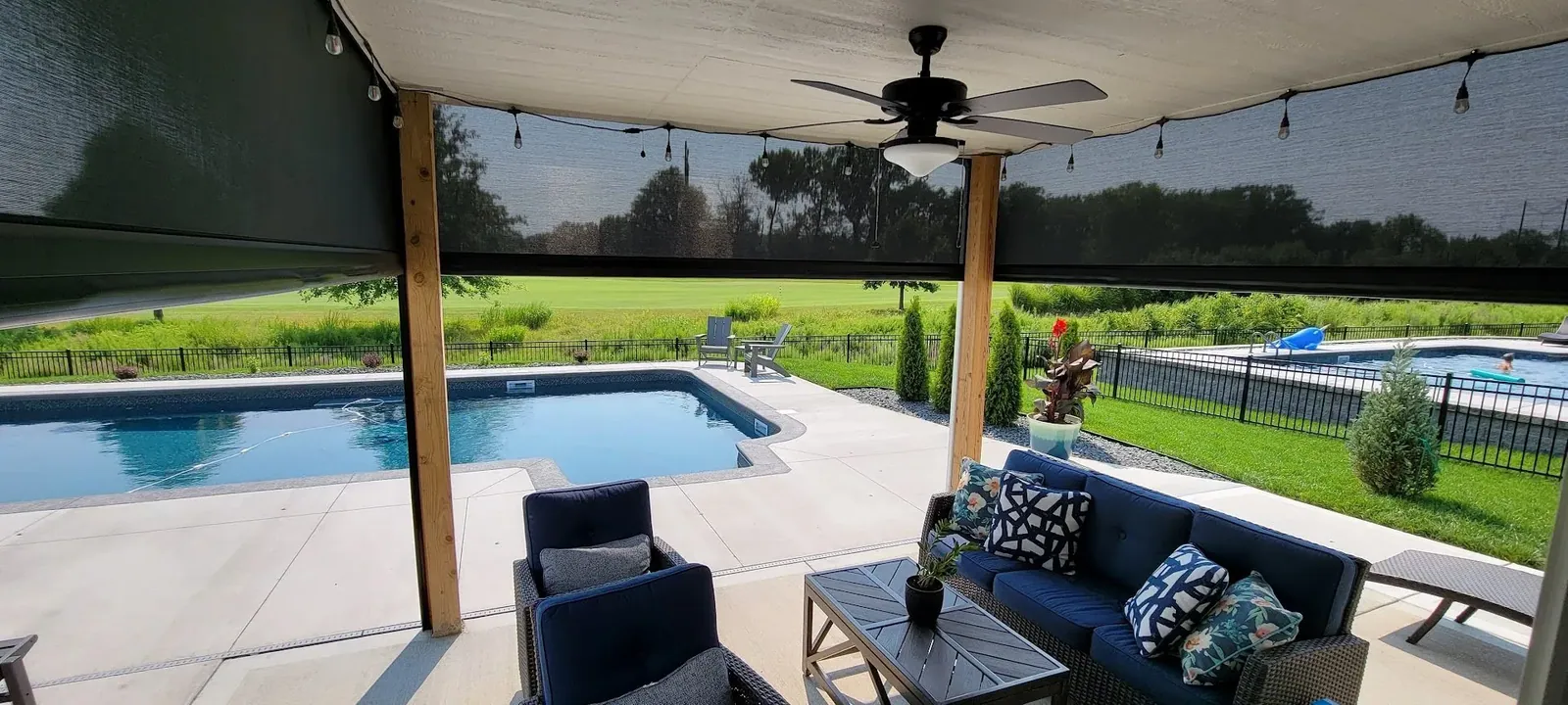 Custom exterior patio shades lower deck with pool backyard, installed by Solar Shield Blinds