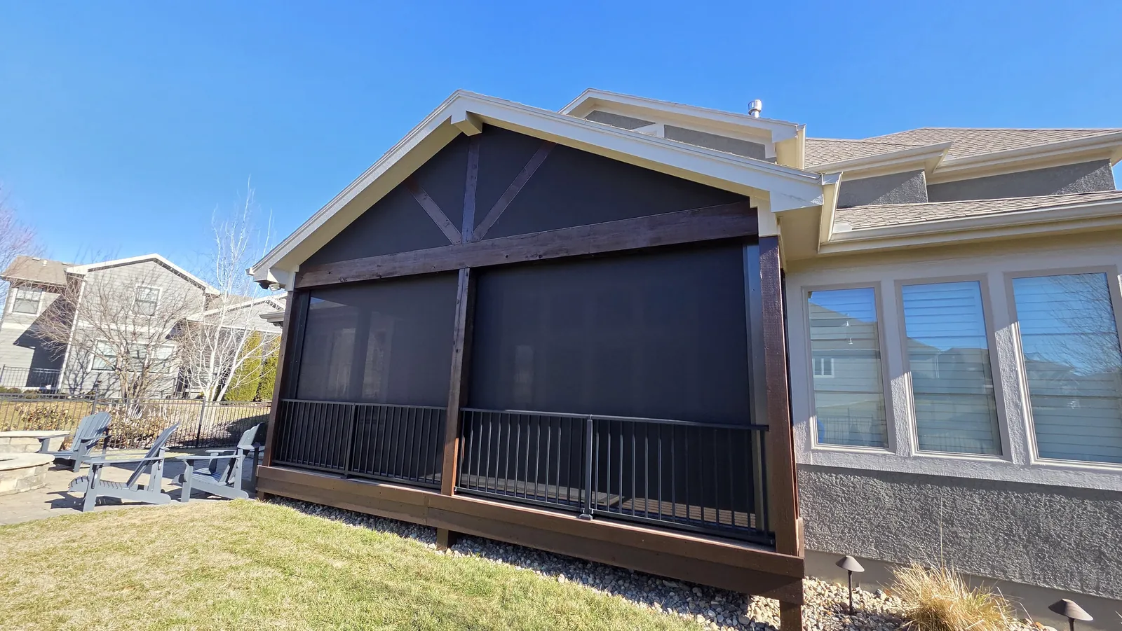 A screened gable porch on a stucco home, seen from the yard