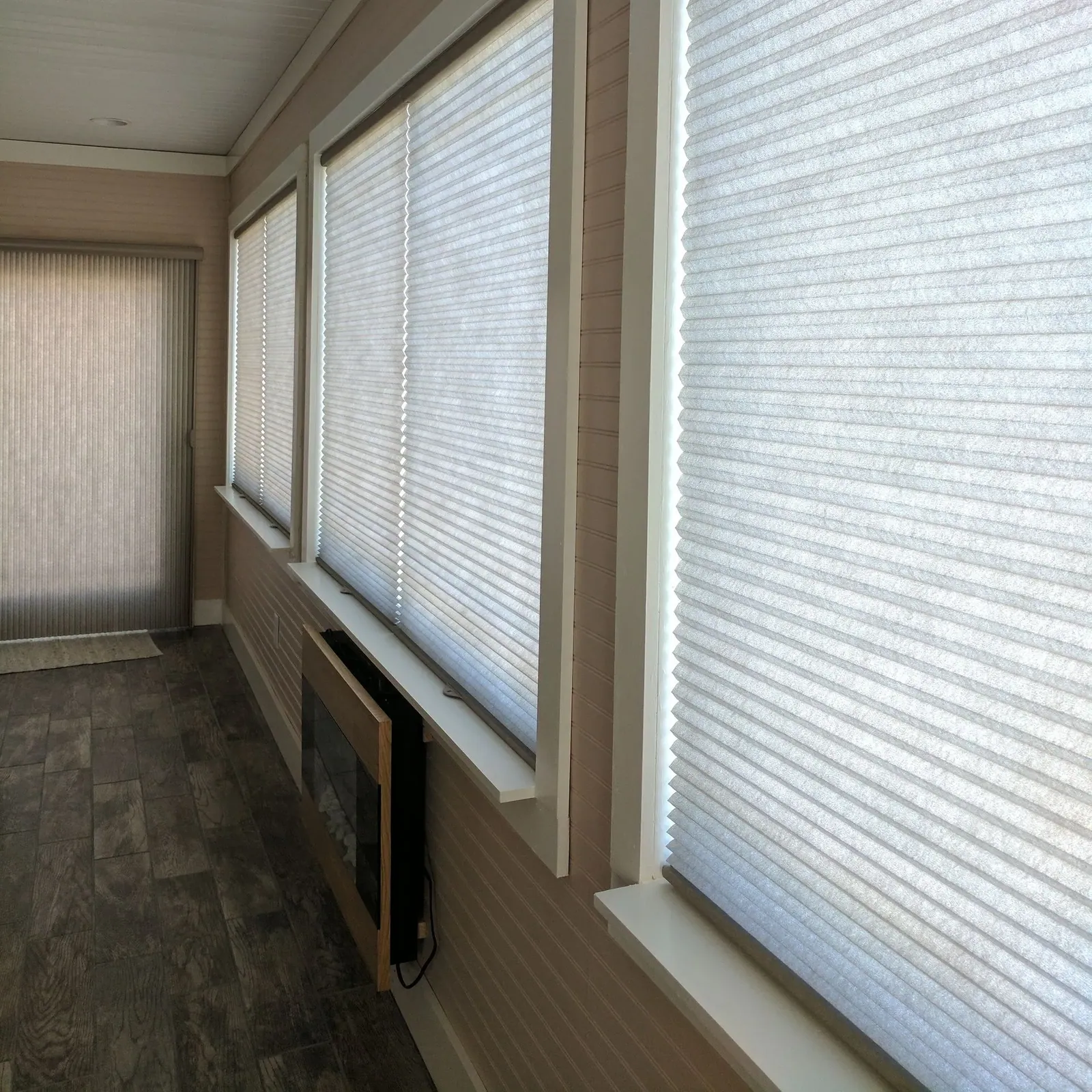 Custom honeycomb shades closed sliding glass door and living room windows, installed by Solar Shield Blinds
