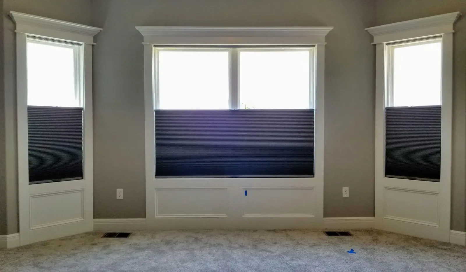 Honeycomb Shades half closed in a living room, installed by Solar Shield Blinds