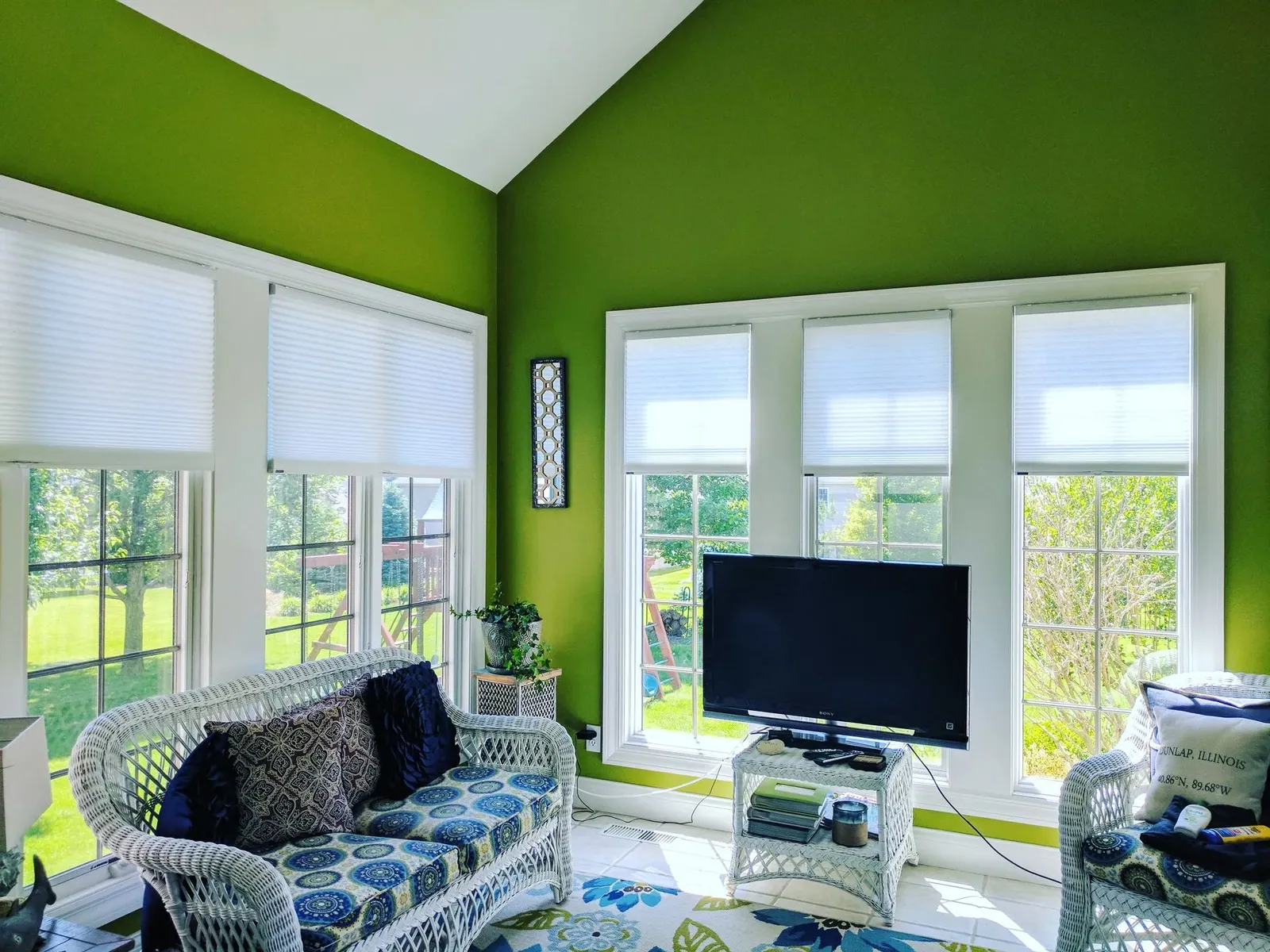 Half opened light filtering honeycomb shades in a sunroom, installed by Solar Shield Blinds