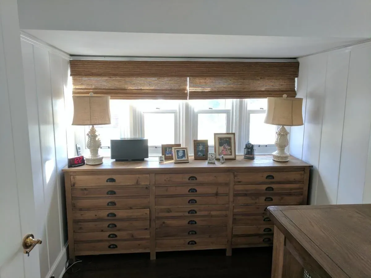 Custom natural woven shades in a bedroom, installed by Solar Shield Blinds