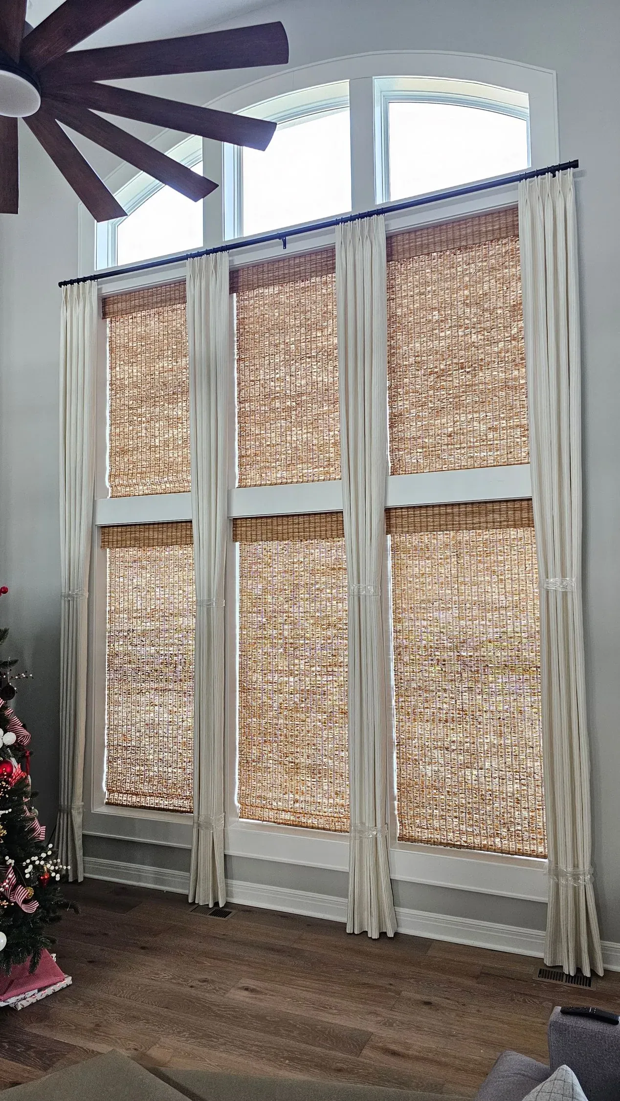 Custom natural woven shades tall window in a living room, installed by Solar Shield Blinds