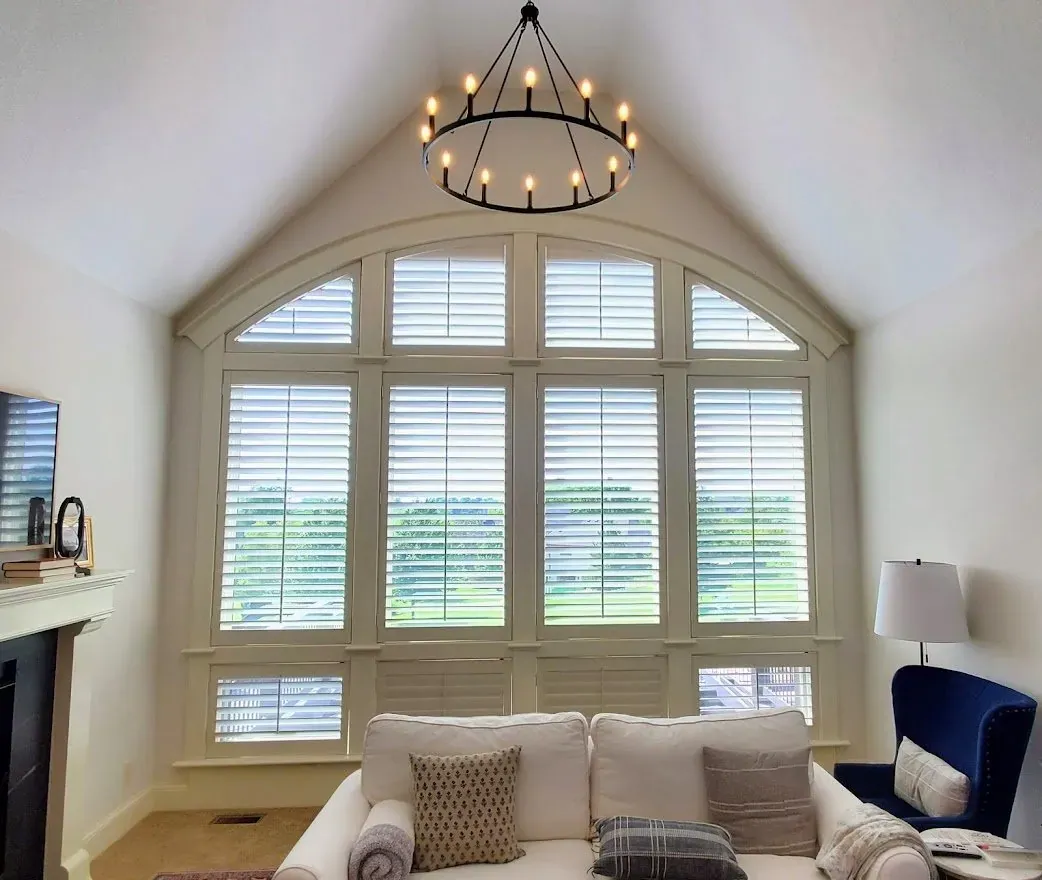 Arched plantation shutters installed in a living room