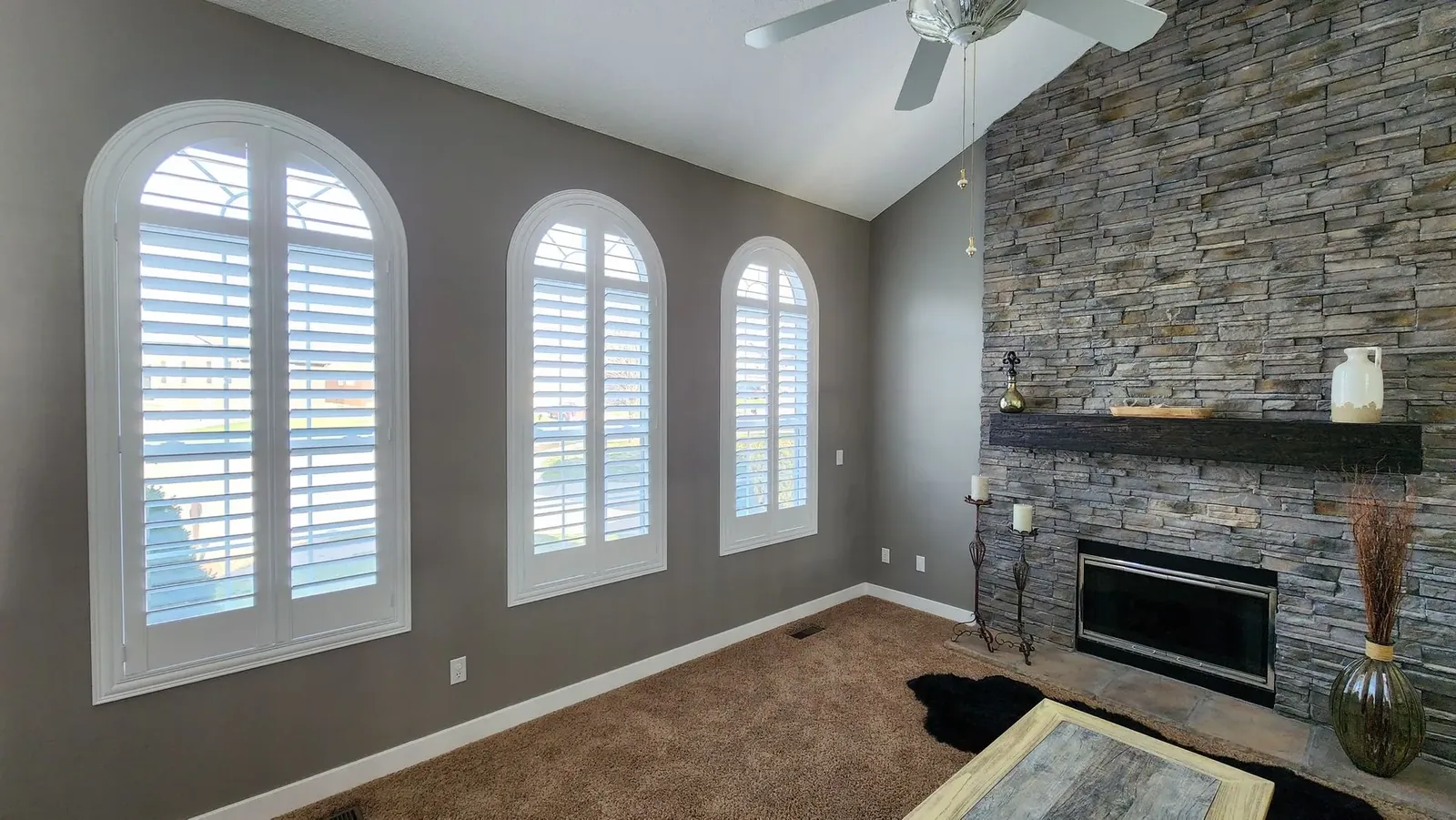 Plantation Shutters arched in a living room, measured and hung by Solar Shield Blinds