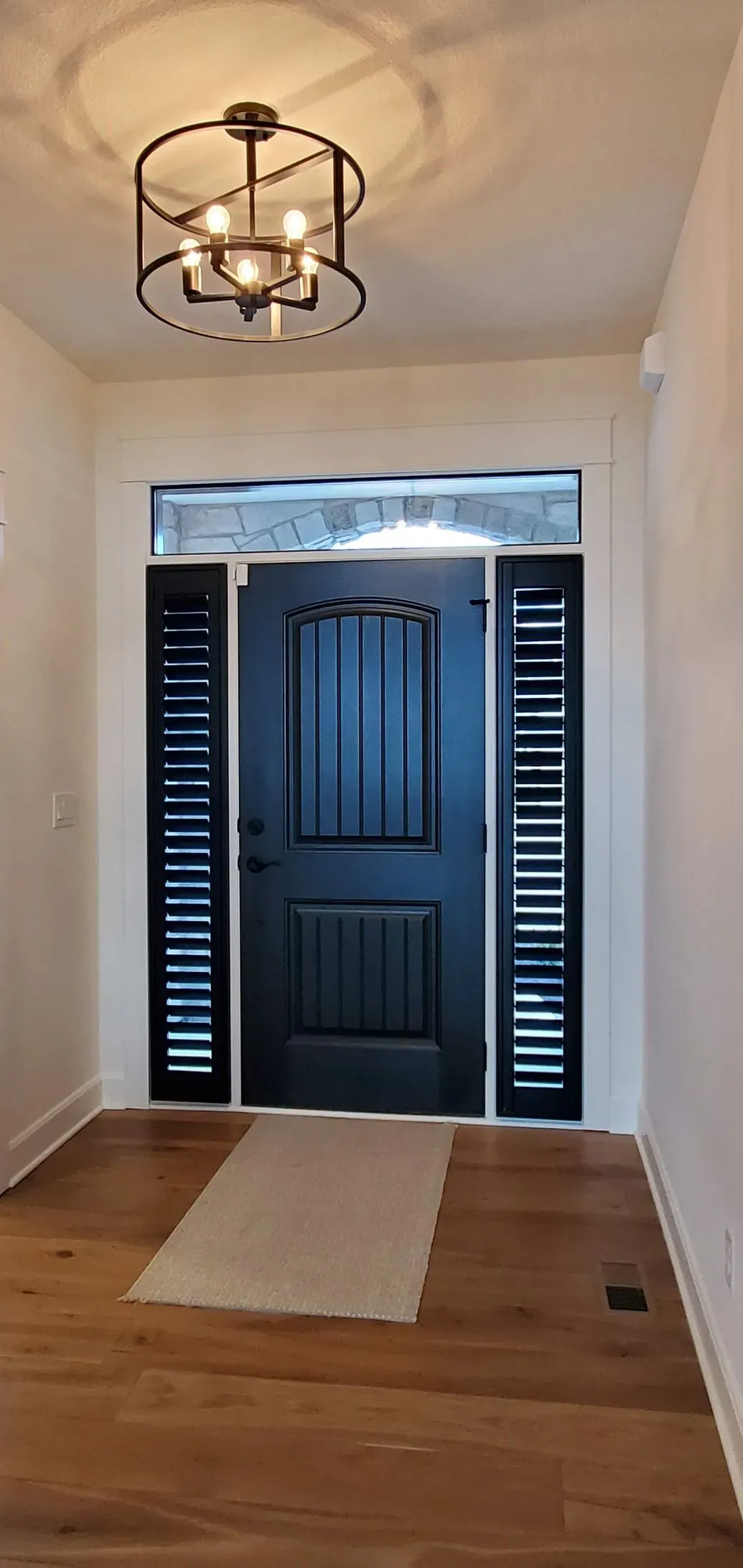 Plantation Shutters black in sidelight front door, a Solar Shield Blinds install