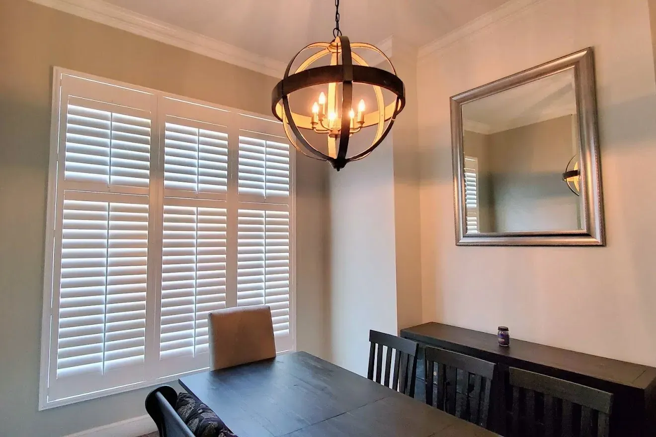 Plantation Shutters closed in a dining room, measured and hung by Solar Shield Blinds