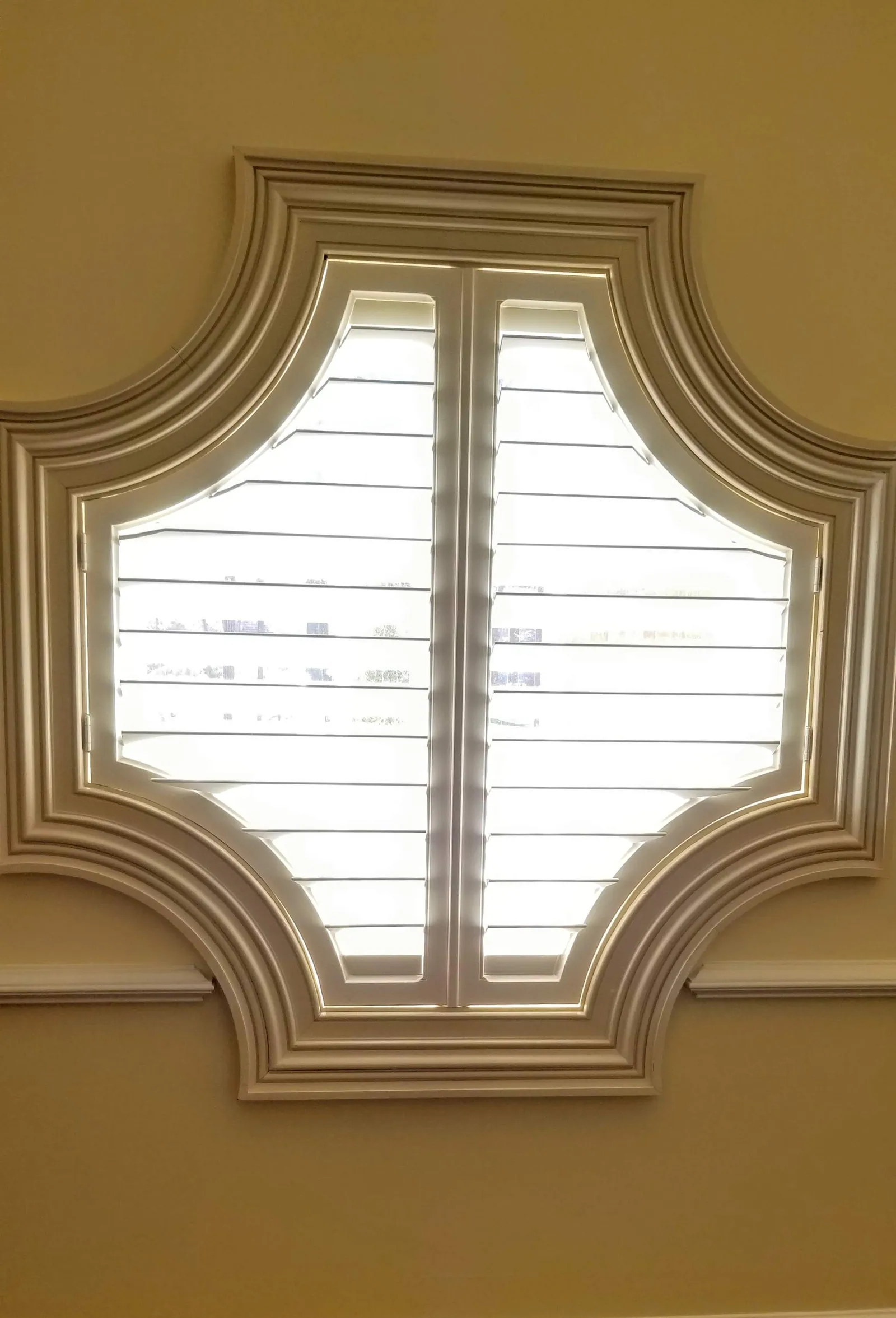 Plantation Shutters closed specialty shaped quatrefoil style window, installed by Solar Shield Blinds