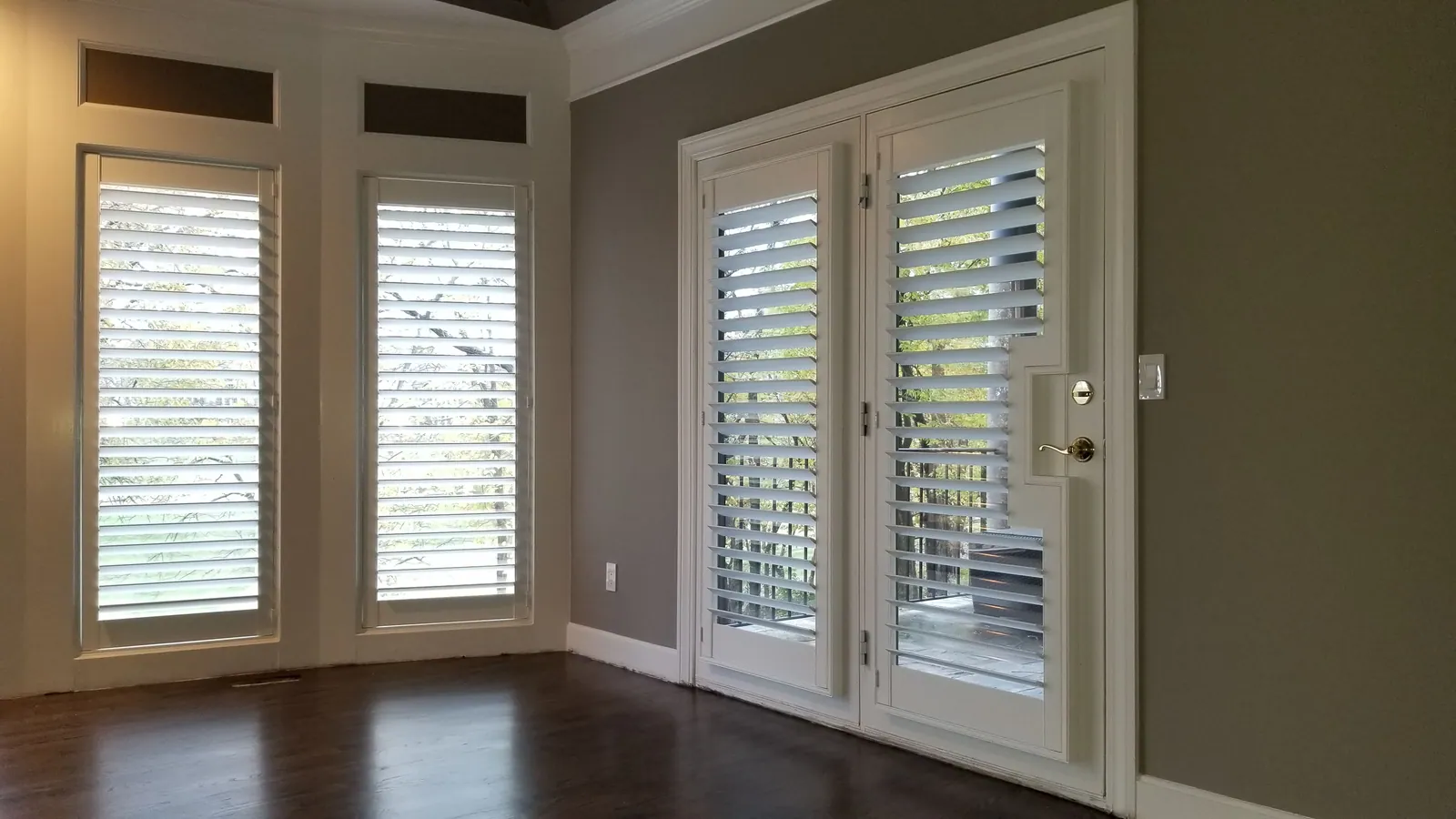 Custom plantation shutters shutter french door cut out in a living room, installed by Solar Shield Blinds