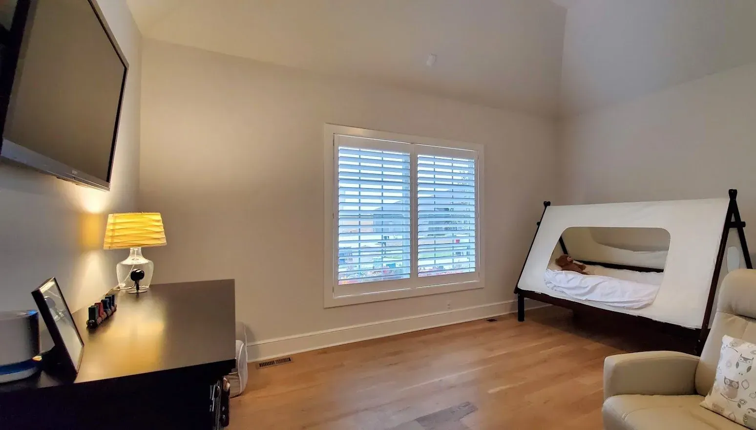 Open plantation shutters in bedroom, installed by Solar Shield Blinds