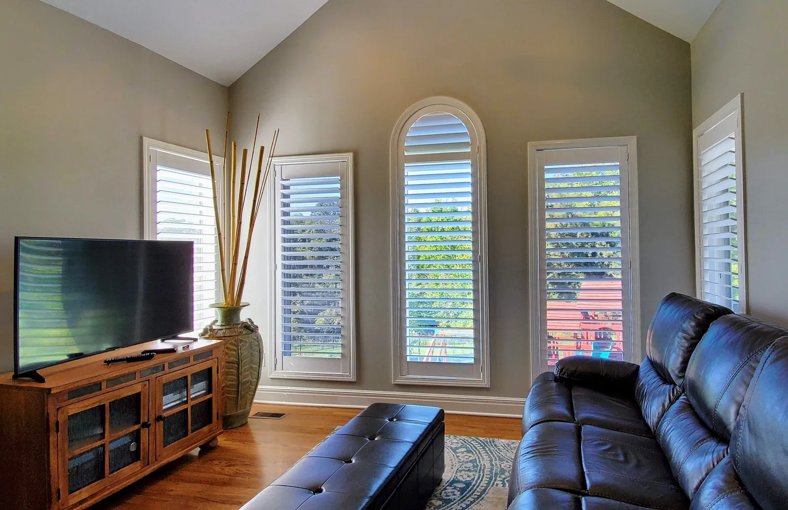 Plantation Shutters specialty arched shape in a living room, measured and hung by Solar Shield Blinds