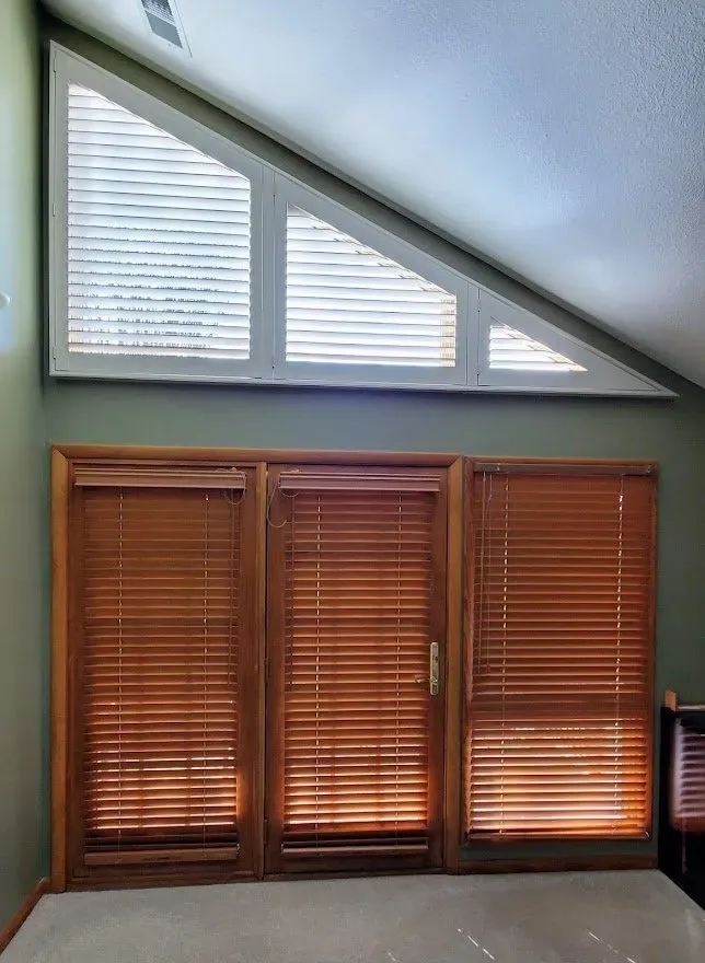 Triangle shaped plantation shutters over a foyer window, installed by Solar Shield Blinds